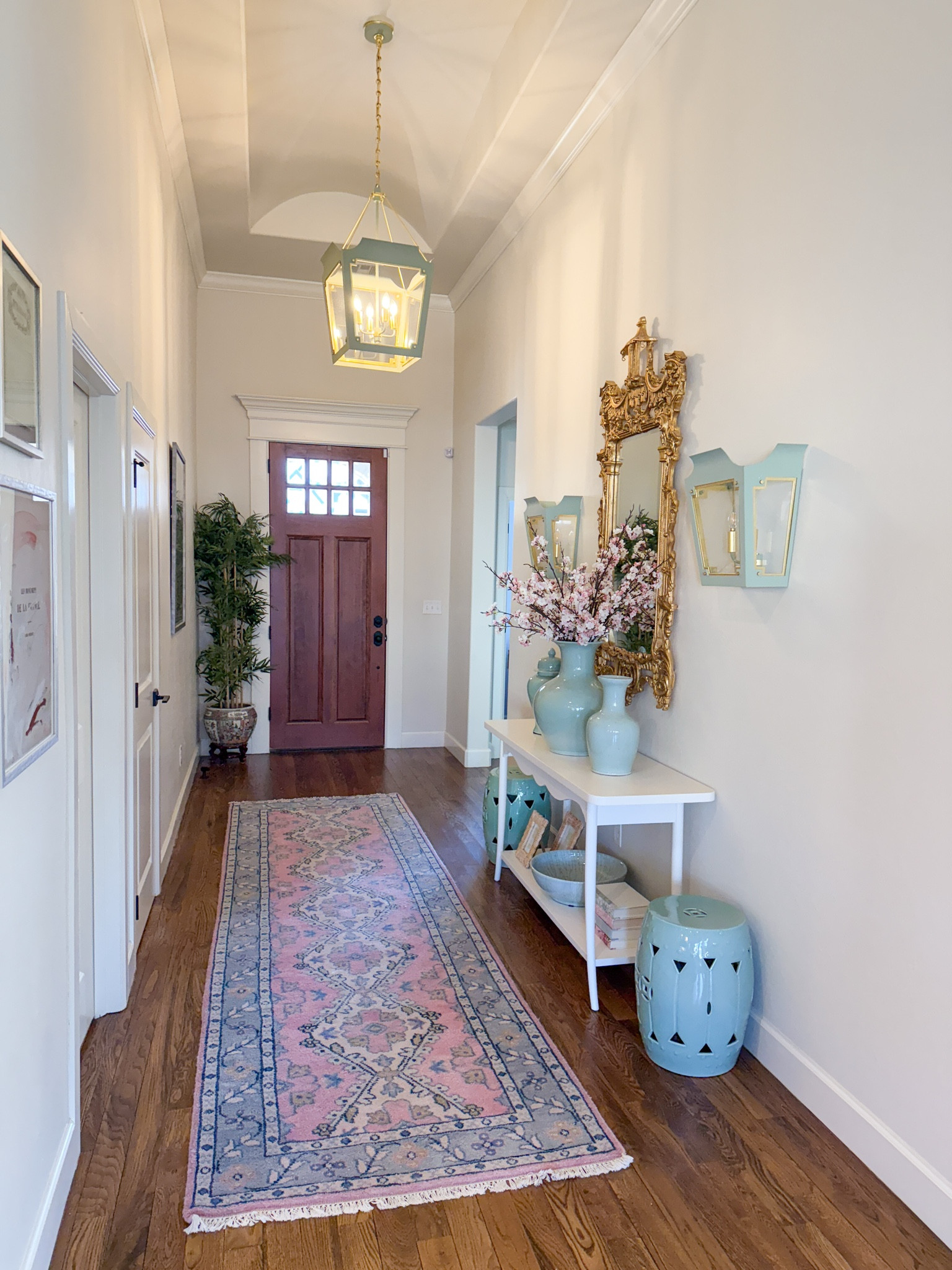 Entryway with console table, rug, sconces, visual comfort, pendant light, gold mirror & garden stools

#LTKHome
