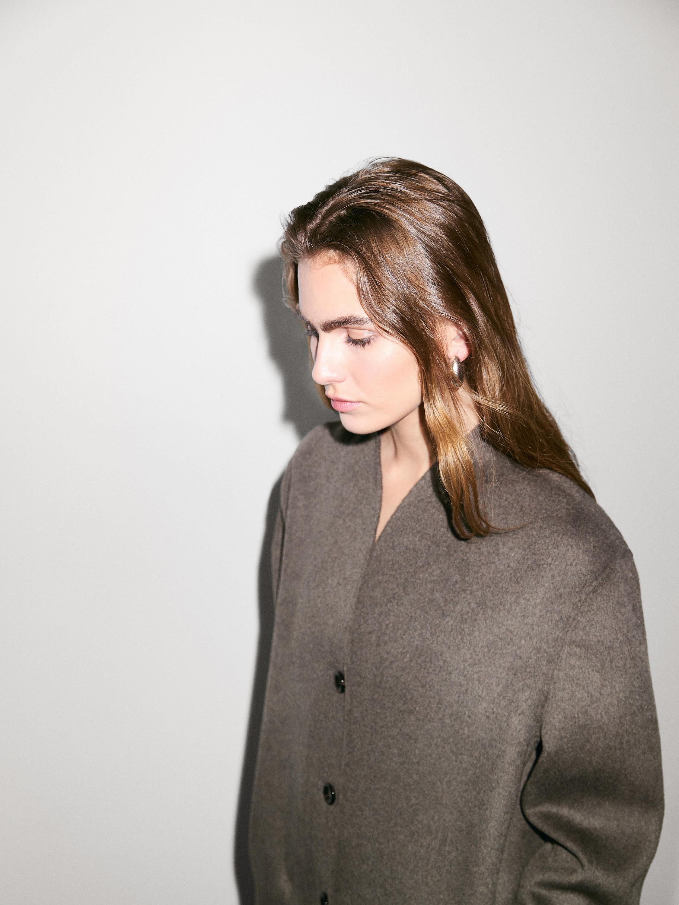 Long coat made of wool blend fabric. High crew neck. Long sleeves. Button-up front. Two side pock... | Massimo Dutti UK