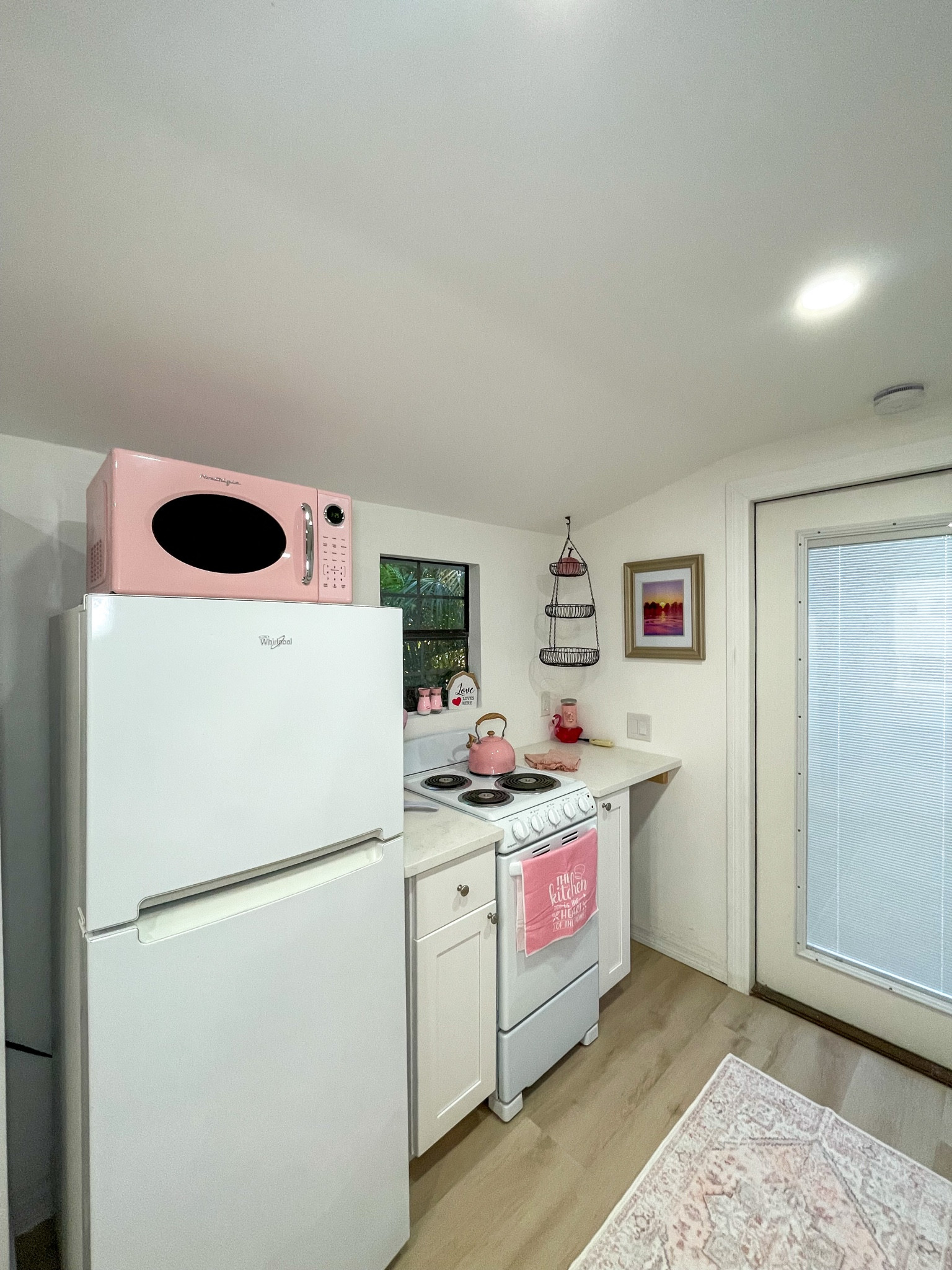 Cottage-style kitchen with the cutest pastel pink appliances.