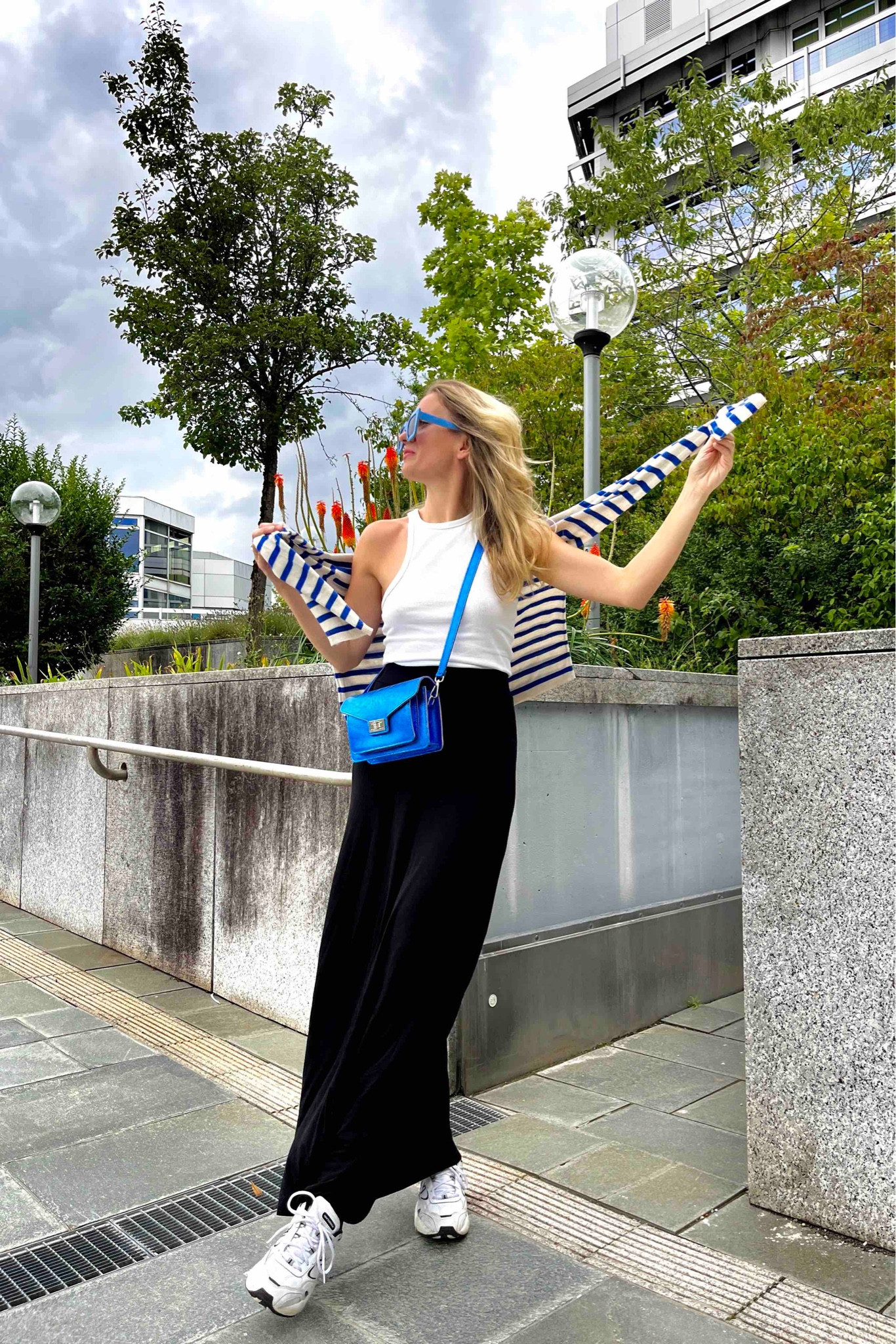 Blue Metallic. Fashion Blogger Girl by Style Blog Heartfelt Hunt. Girl with blond hair wearing a blue striped sweater, blue metallic bag, blue oversized sunglasses, white top, maxi skirt and New Balance sneakers. #stripedsweater #maxiskirt #metallicbag #colorfuloutfit #colorfulstyle #colorfulfashion #colorfullooks #fashionfun #cutesummeroutfit #summerfashion2023 #summerlookbook #fitcheck #dailylooks #dailylookbook #contentcreator #microinfluencer #discoverunder20k