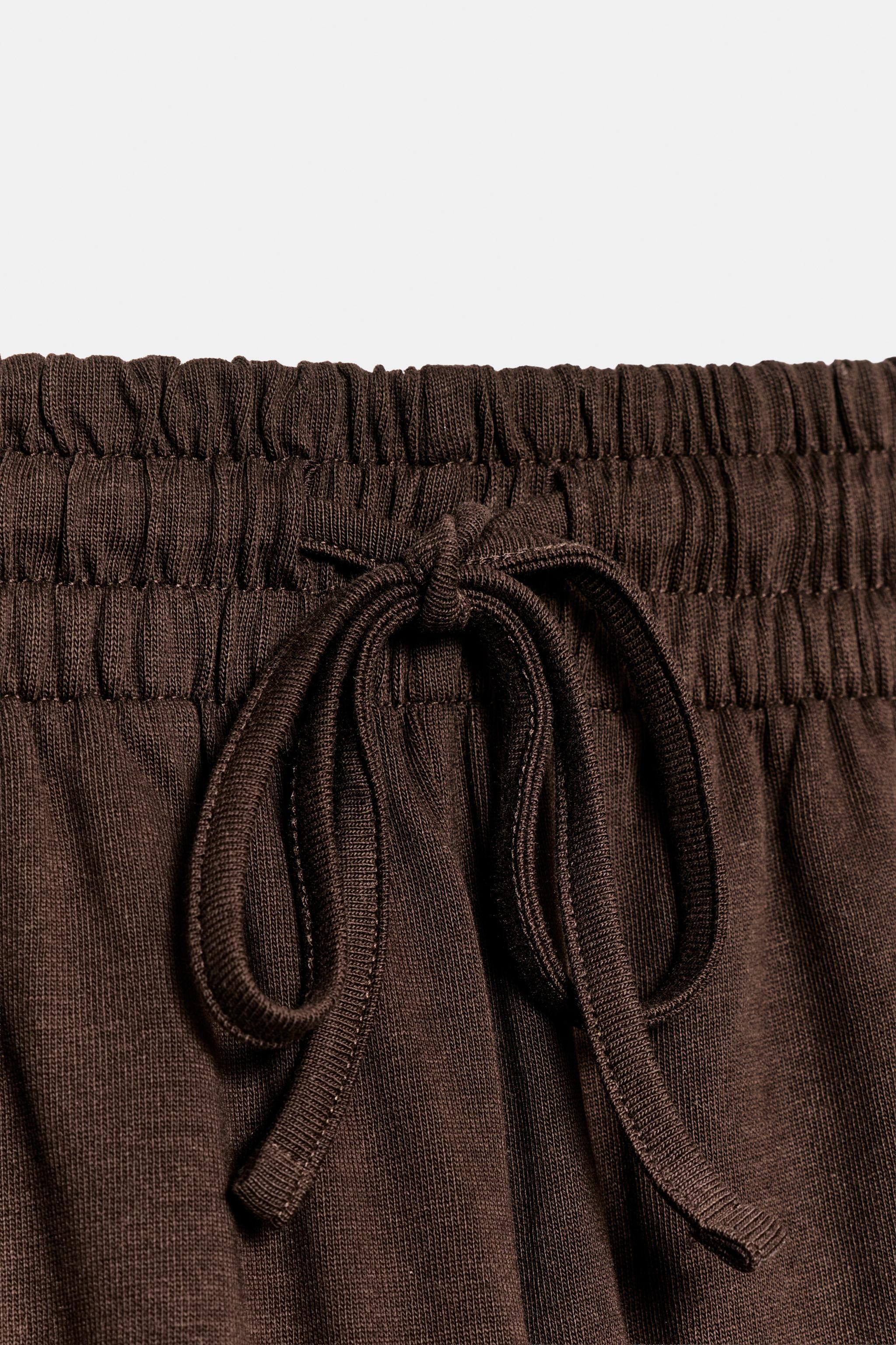 Pants made primarily with cotton yarn. Mid-rise with an adjustable elastic waistband featuring ti... | Zara US