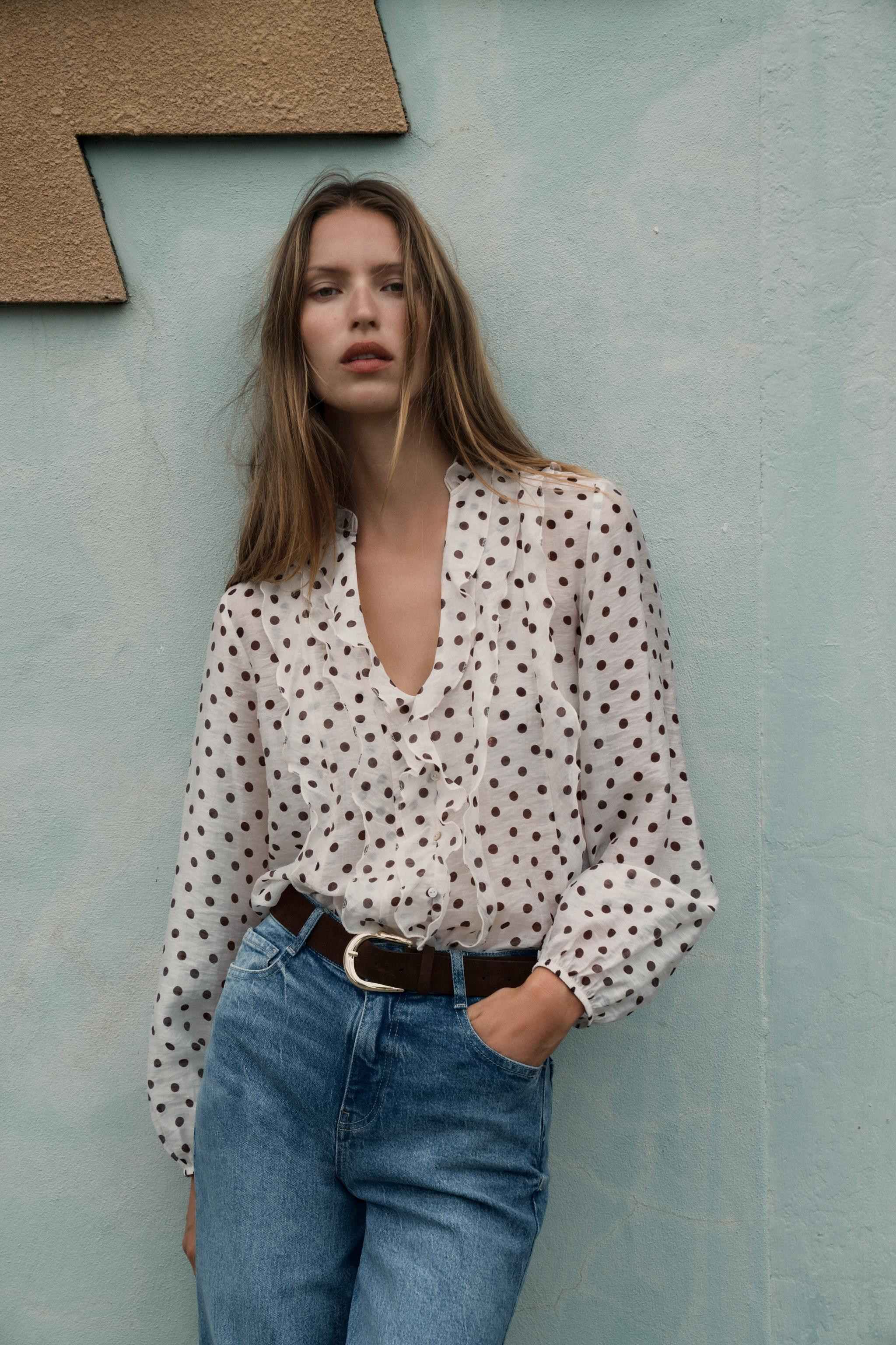 V-neck blouse with ruffles and long sleeves with elastic cuffs. Faux front buttons. | Zara US