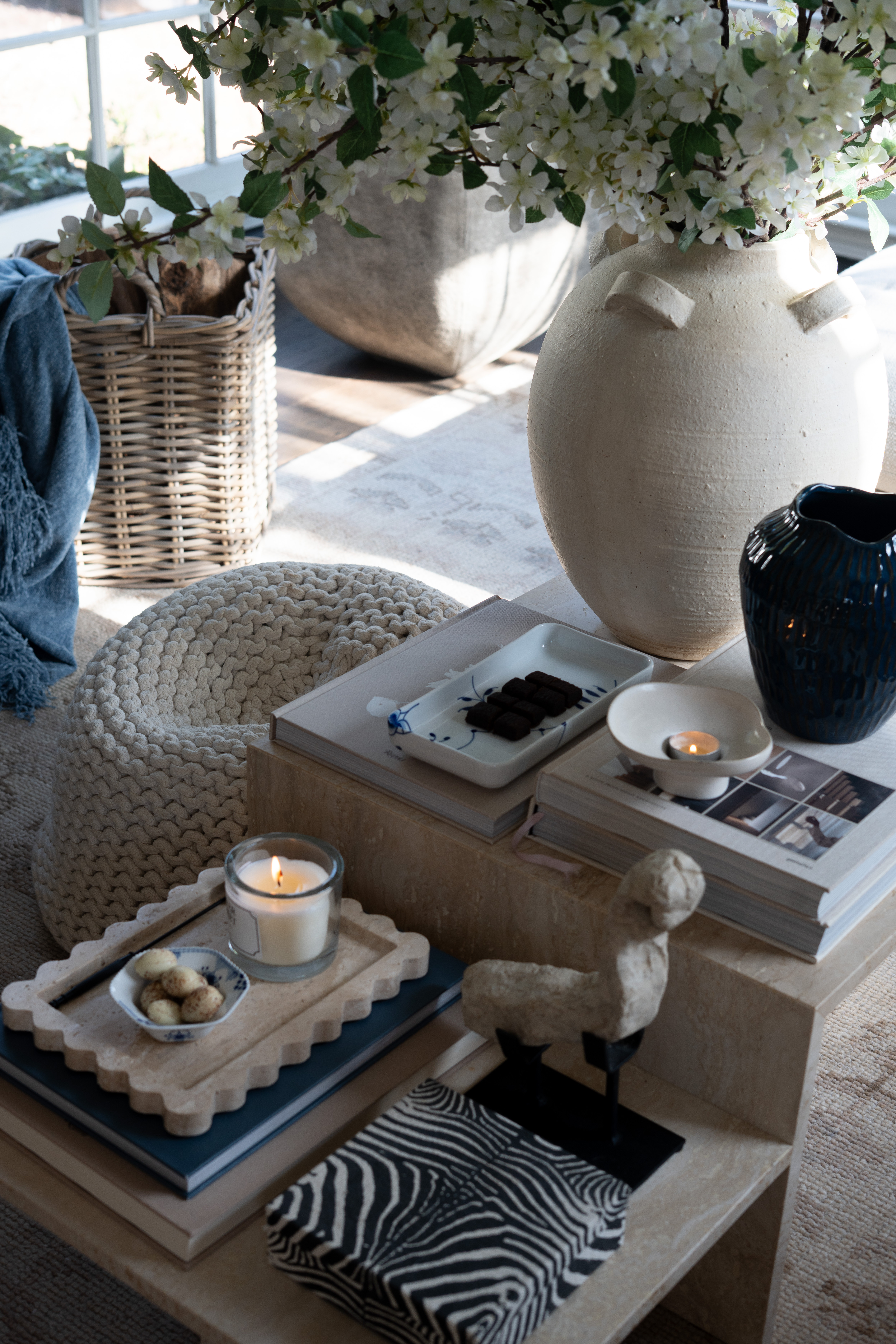 I love when a space feels both calm and elevated at the same time. The oversized ceramic vase, spring blossoms, stacked design books, candlelight, and layered neutral textures create the perfect cozy living room moment.  

 #LTKSpringSale #LTKSeasonal #LTKHome