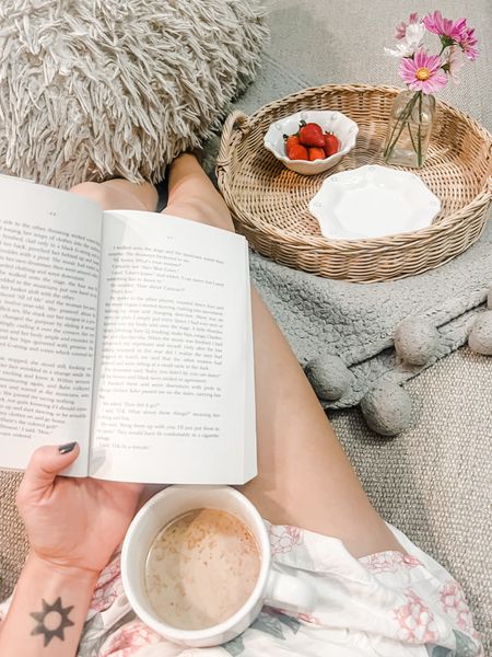 Cozy spring morning reading on the couch with a latte in a large mug and a woven tray full of pretties - berry bowl of strawberries and small bud vase of cosmo flowers.

Cozy furry pillow, softest Pom Pom throw blanket, Maya Angelou book, reading, rainy mood, butler tray, large coffee mug 

#LTKunder50 #LTKwedding #LTKhome