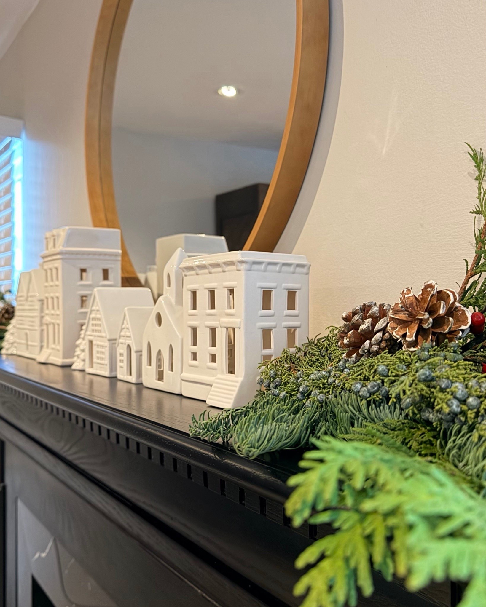 Holiday mantel decor that feels cozy, simple, and timeless. I styled this mantel with a soft evergreen garland, ceramic village houses, pinecones, and warm candlelight layered in front of a round mirror for added height and glow. A classic holiday look that works from Thanksgiving through Christmas and makes the whole room feel inviting.

#LTKHome #LTKHoliday #LTKFindsUnder100