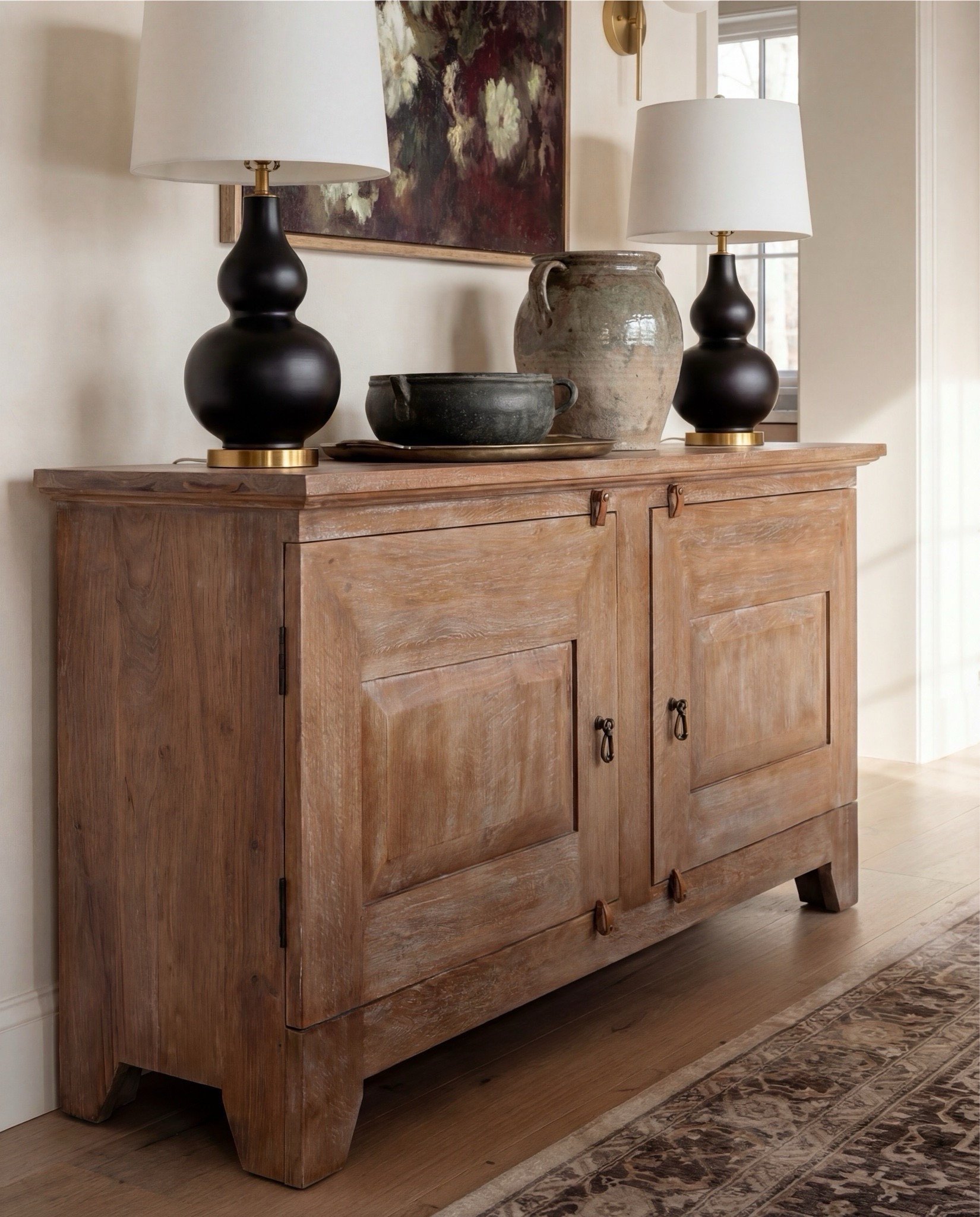 Shop the Look:
• Solid wood dining table (natural oak tone)
• Cane-back dining chairs with upholstered seats
• Upholstered accent dining chair (cream boucle)
• Vintage-style area rug (neutral, muted pattern)
• Exposed wood ceiling beams
• White globe pendant light with brass stem
• Brass wall sconces with globe shades
• Wood sideboard/buffet cabinet
• Black table lamp with white shade
• Ceramic table lamp (neutral glaze)
• Framed abstract artwork
• Glass-front wood hutch cabinet
• White sculptural ceramic bowl (table centerpiece)
• Potted olive tree (faux or real)
• Light wood flooring
• Large windows with simple trim


#LTKSaleAlert #LTKHome