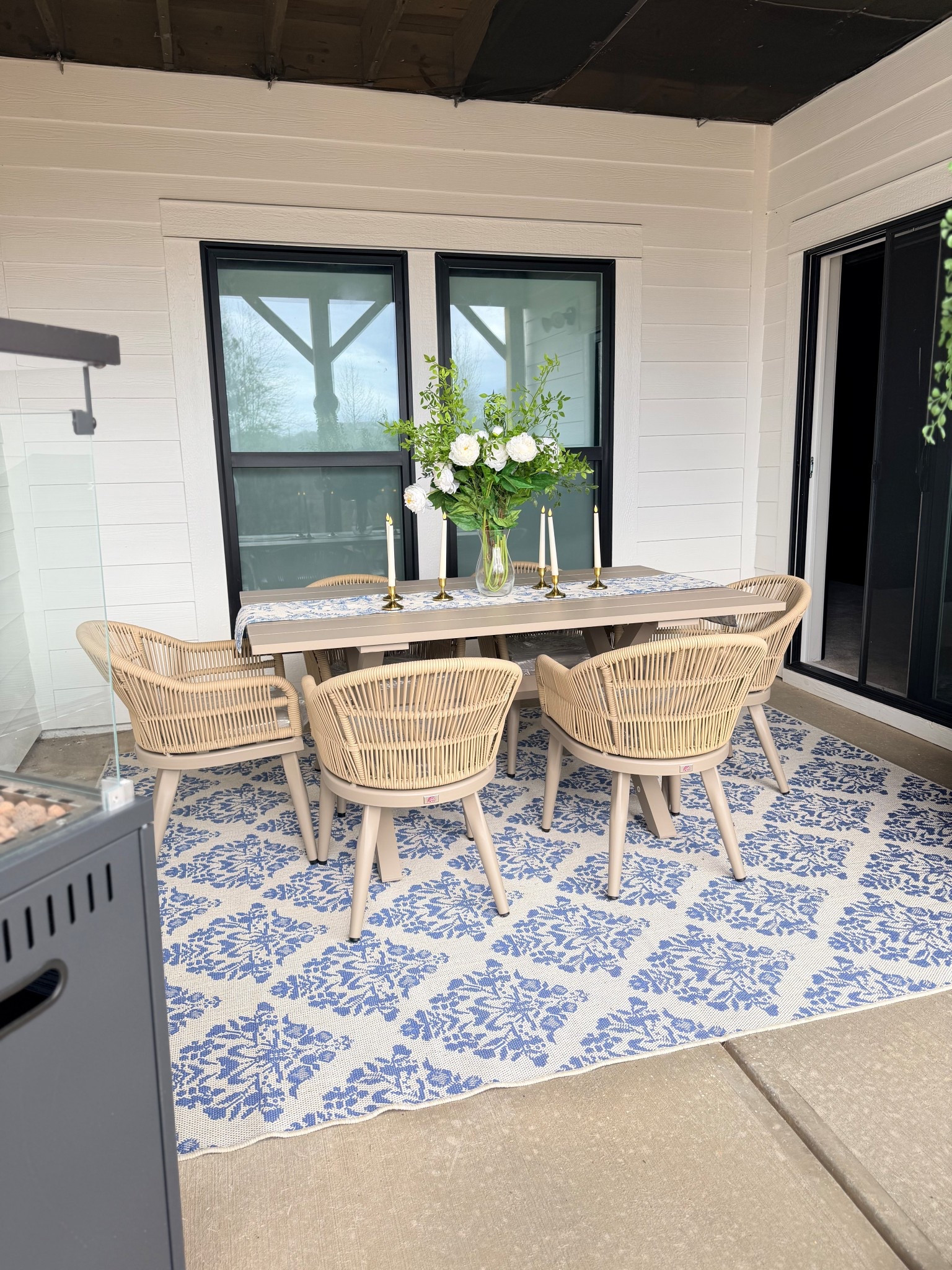 Creating an outdoor space that feels just as cozy and styled as the inside of our home was a must for me. This patio dining setup has quickly become one of my favorite spots perfect for slow mornings, dinners with friends, and everything in between.

I kept the palette light and neutral with woven textures, soft taupe tones, and a classic blue patterned rug to bring a little character to the space. The layered table runner, candles, and fresh florals make it feel elevated but still relaxed and welcoming.

#LTKOver40 #LTKSeasonal #LTKHome