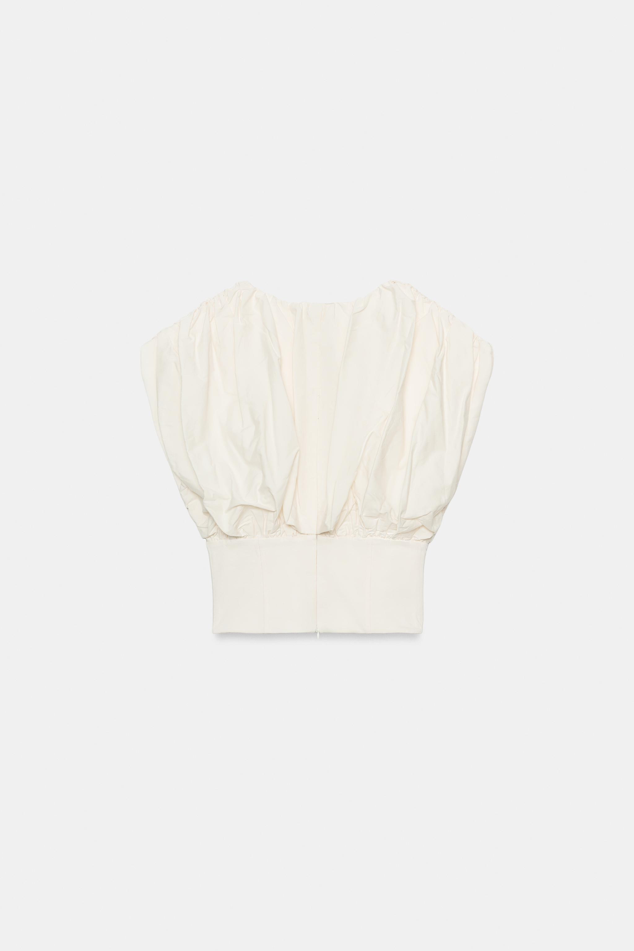 Top crafted from cotton yarn. Featuring a round neck, sleeveless design, straight hem and zip fas... | Zara UK