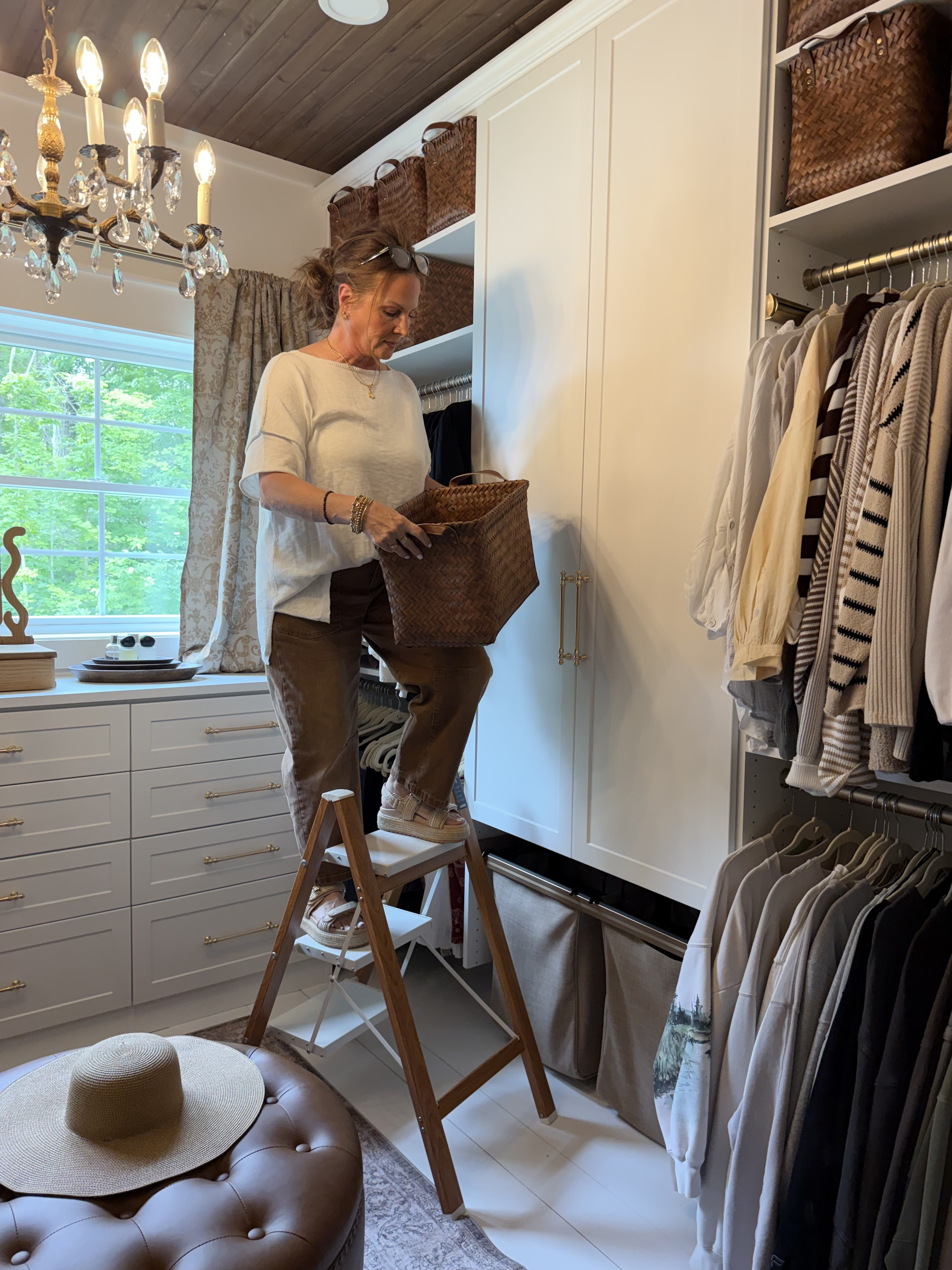 I finally finished organizing and decorating our new walk-in closet in the master bedroom. It features a full-sized chandelier, my curtains from Walmart, gold drawer pulls, a storage ottoman, and storage baskets.  

 #LTKHome