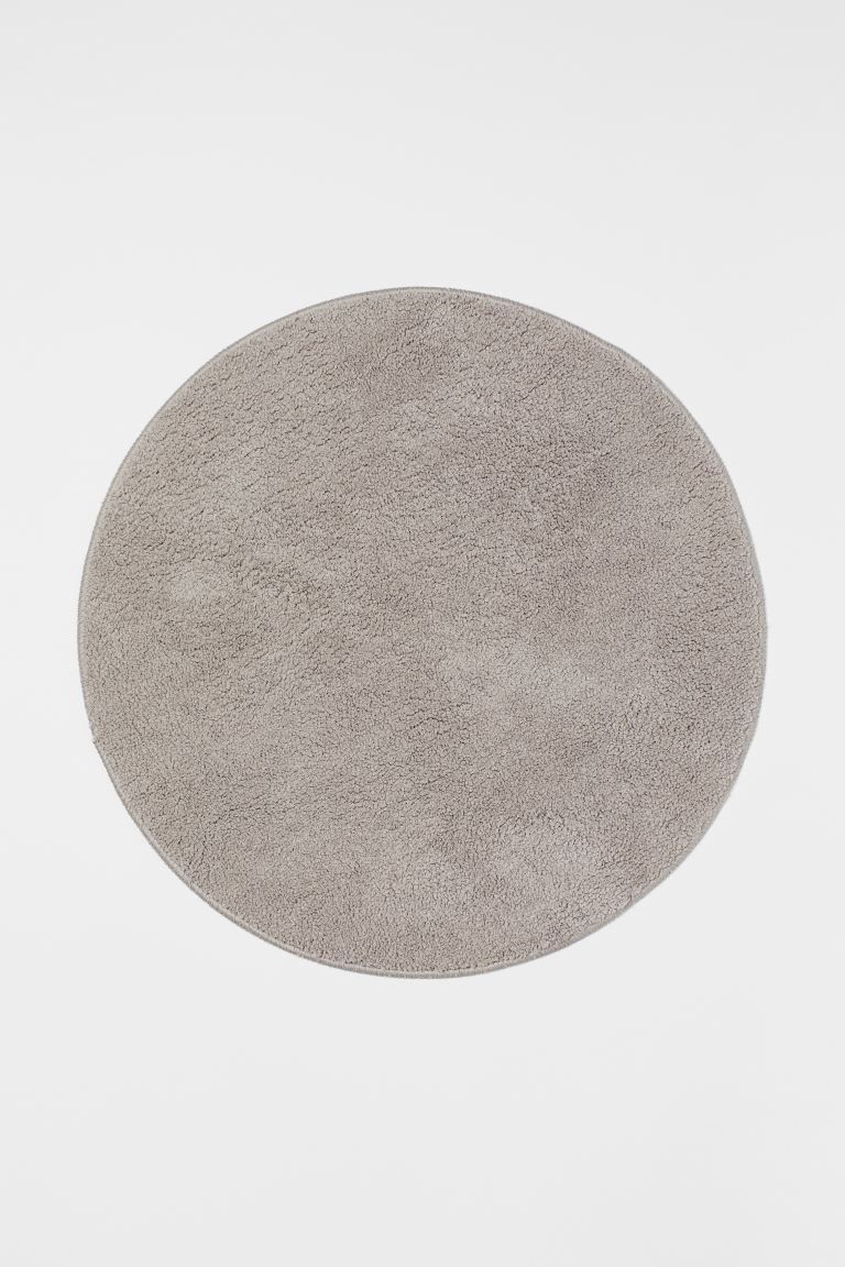 Round bath mat in soft fabric made from recycled polyester. Non-slip protection at back. Do not u... | H&M (US + CA)