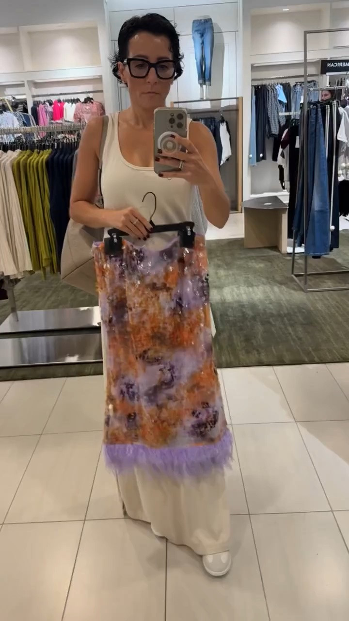 This statement skirt is absolutely stunning! The combination of warm orange, soft lavender, shimmering sequins, and feather trim makes it such a special piece. I love the texture and movement, and I would style it with a simple fitted top and heels to let the skirt do all the talking. Perfect for a fall event, dinner party, or a special occasion when you want something memorable.

sequin skirt, feather trim skirt, statement skirt, embellished skirt, fall event outfit, special occasion outfit, colorful midi skirt, holiday party outfit, women over 50 style, elegant evening style, fall fashion, stylewitheugenia