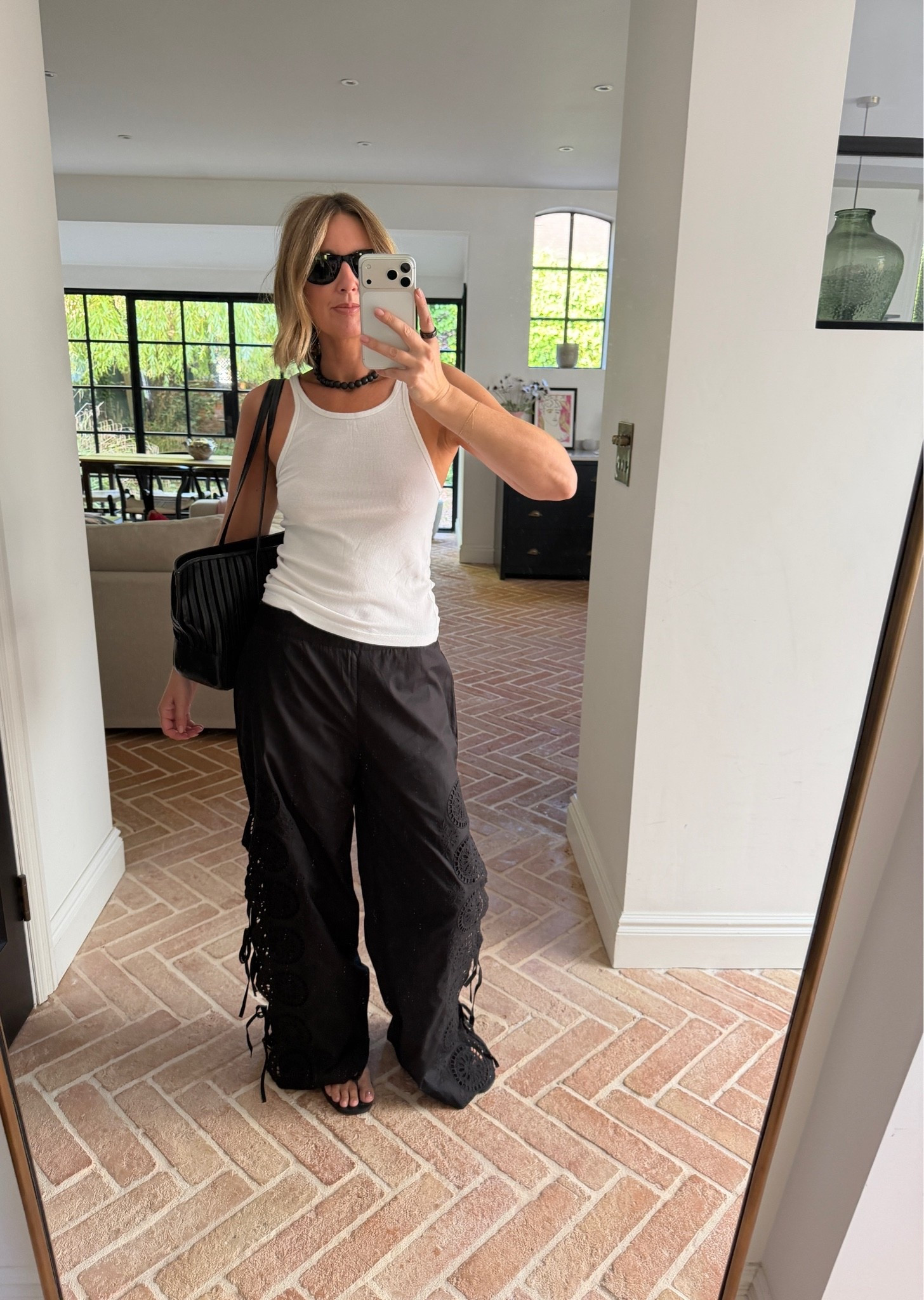 white ribbed tank top, scoop neck tank, black crochet lace trim pants, black wide leg pants, embroidered cotton pants, boho beach pants, black chunky necklace, statement necklace, black quilted shoulder bag, black flip flops, thong sandals, black sunglasses, boho summer style, resort style, monochrome outfit, quiet luxury, elevated basics, effortless summer style, ltkstyletip, ltkseasonal, ltksummer, ltkfindsunder100, outfit inspo, capsule wardrobe essentials

#LTKsummer #LTKeurope #LTKdatenight