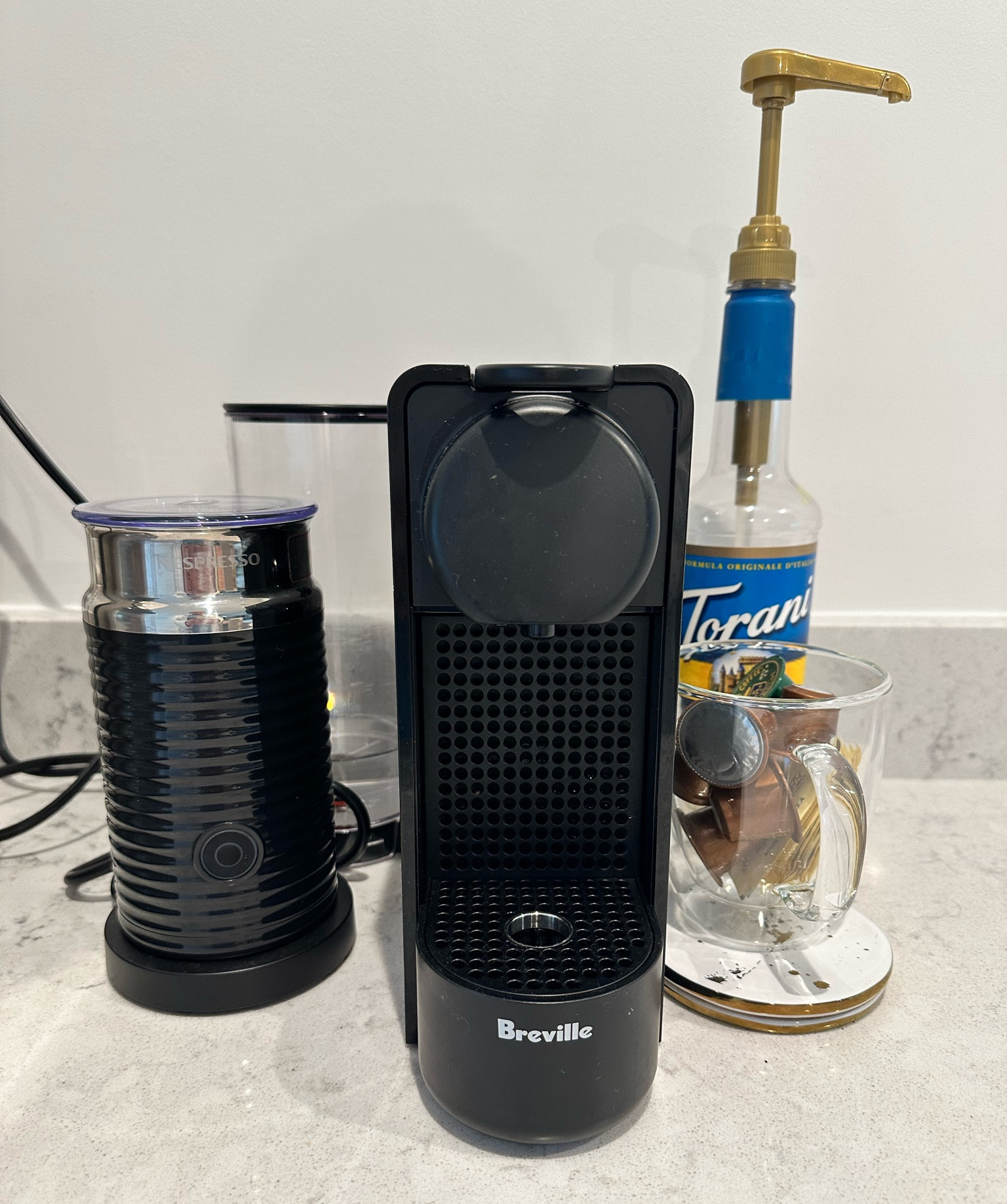 Ok I need to make this area a little more aesthetically pleasing but I love this thing so I figured I’d share again. I have the original style nespresso (the little pods) and I’m addicted to the frother that came with it. The clear glasses from Target are so cute, I keep one filled with my off brand nespresso pods 🤫 and you just can’t go wrong with Torani flavors!

#coffeebar #nespresso

#LTKhome