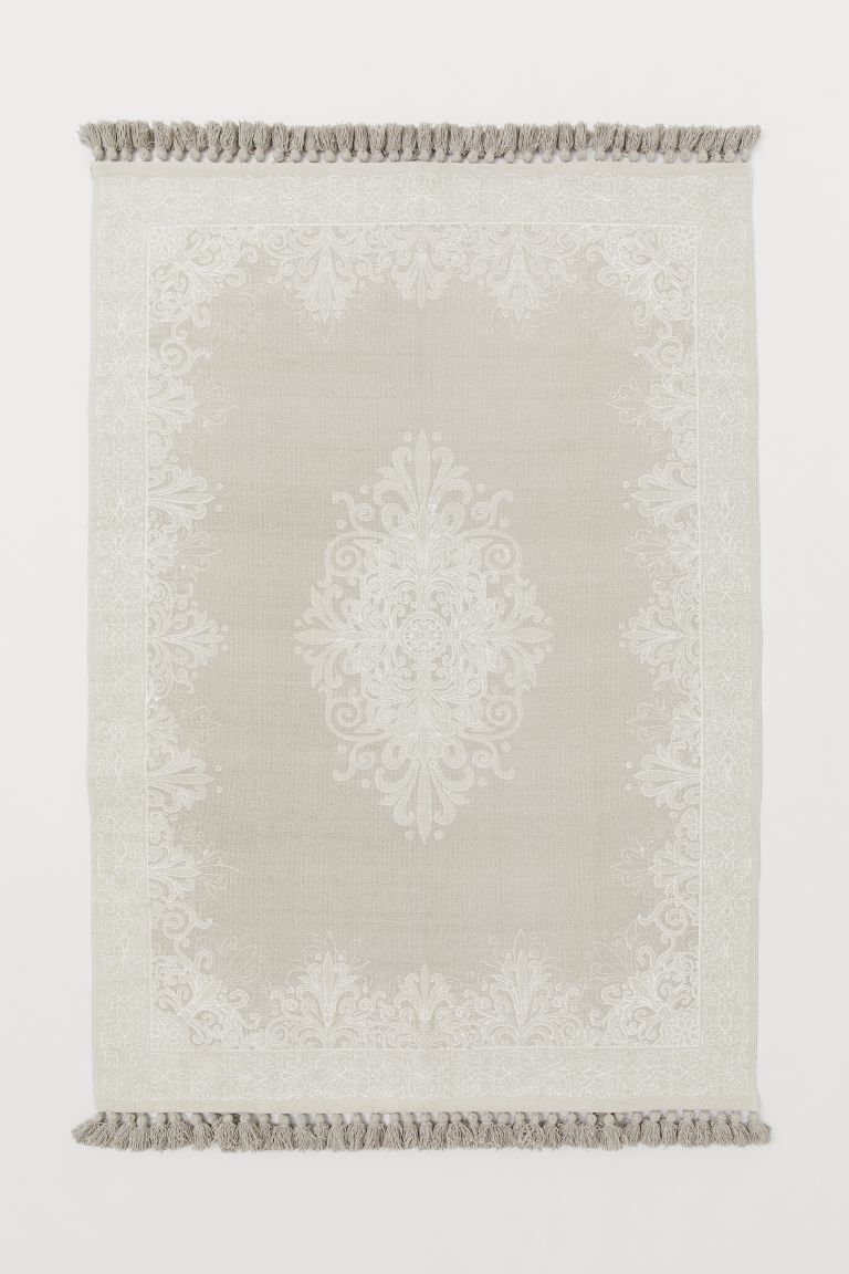 Rectangular rug in woven, recycled cotton fabric with a printed pattern at front. Tassels at shor... | H&M (US + CA)