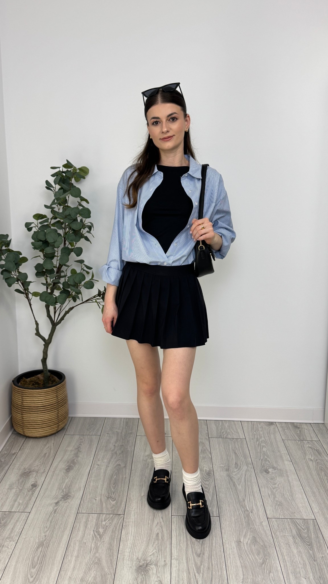 Black mini pleated skirt, black long sleeve top, light blue striped shirt, white socks, black loafers, black purse, and sunglasses. A cute look with effortless edgy energy 🩵 #IlaStylesDiary 

#LTKeurope #LTKworkwear #LTKspring