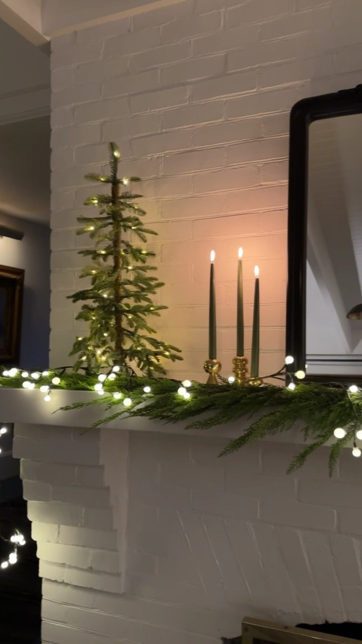 A simple, chic, warm & cozy fireplace decor formula: one strand of garland (I love this cedar version that I paired with berry-shaped lights from Terrain), two cheery and quiet mini Christmas trees (one for each side!), and a smattering of candles in brass holders (for a little polish and sparkle). Easy, simple, timeless - what else can you ask for from your Christmas decor? #shopterrain #ad

#LTKhome #LTKVideo #LTKHoliday