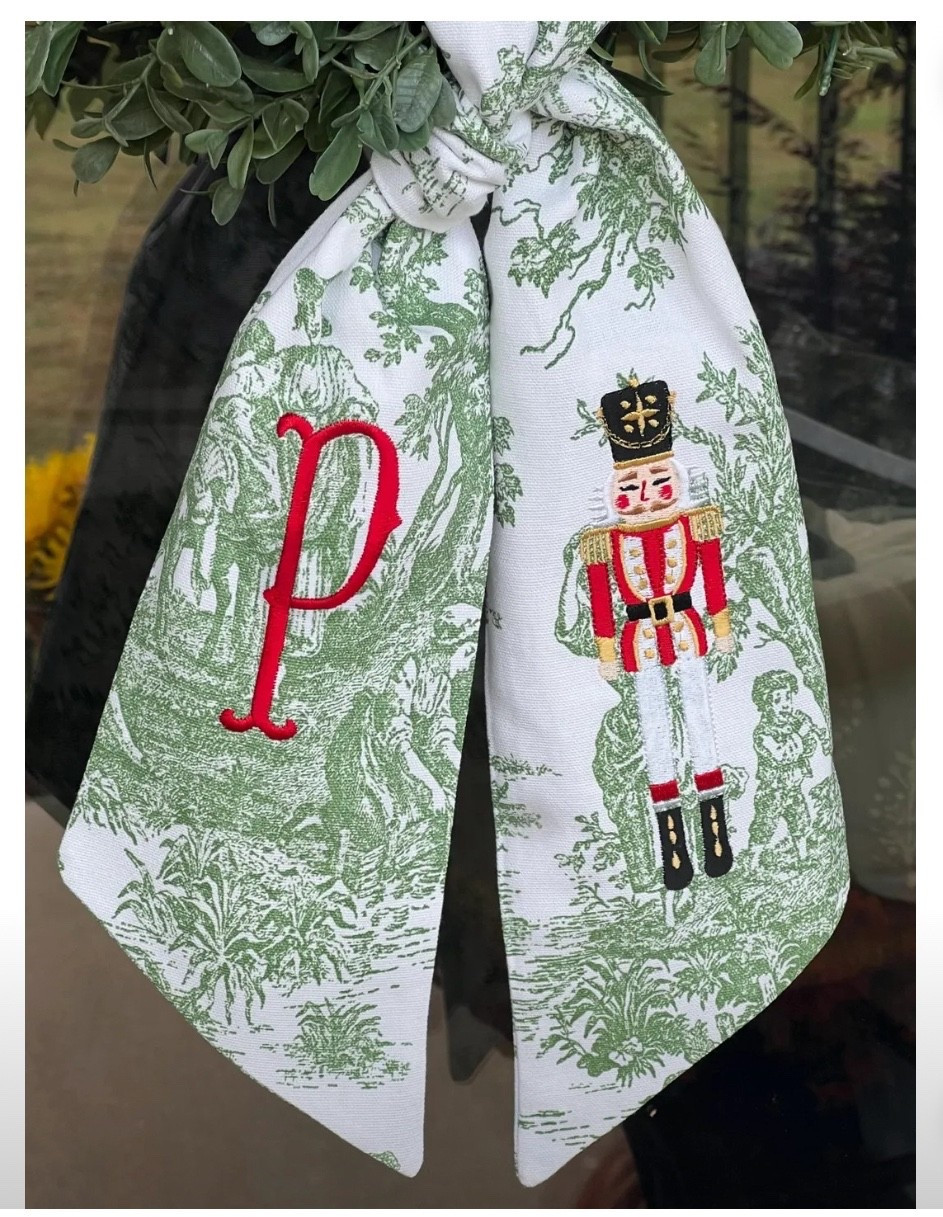 This wreath sash is the holiday bow moment your front door has been waiting for 😍✨ The green toile is so classic + Southern, and the embroidered nutcracker + monogram combo feels like something from a charming historic inn or Southern Living magazine. It instantly dresses up even the simplest wreath — no giant bow needed, just tie and done 🎄

It’s such a sweet way to add personalization to your porch without going over-the-top. Looks gorgeous on boxwood, cedar, flocked, or even faux wreaths. And because it’s fabric, it hangs beautifully — no stiff ribbon here 🤍

🎀 Personalized initial
🌲 Embroidered nutcracker detail
✨ Green toile fabric (obsessed)
🏡 Instantly elevates your front door

⸻

christmas wreath sash • nutcracker holiday decor • grandmillennial christmas aesthetic • southern porch styling • classic christmas door decor • toile holiday ribbon • embroidered wreath bow • charming christmas details • front door holiday styling • hostess gift idea 🎄✨

#LTKHome #LTKGiftGuide #LTKHoliday