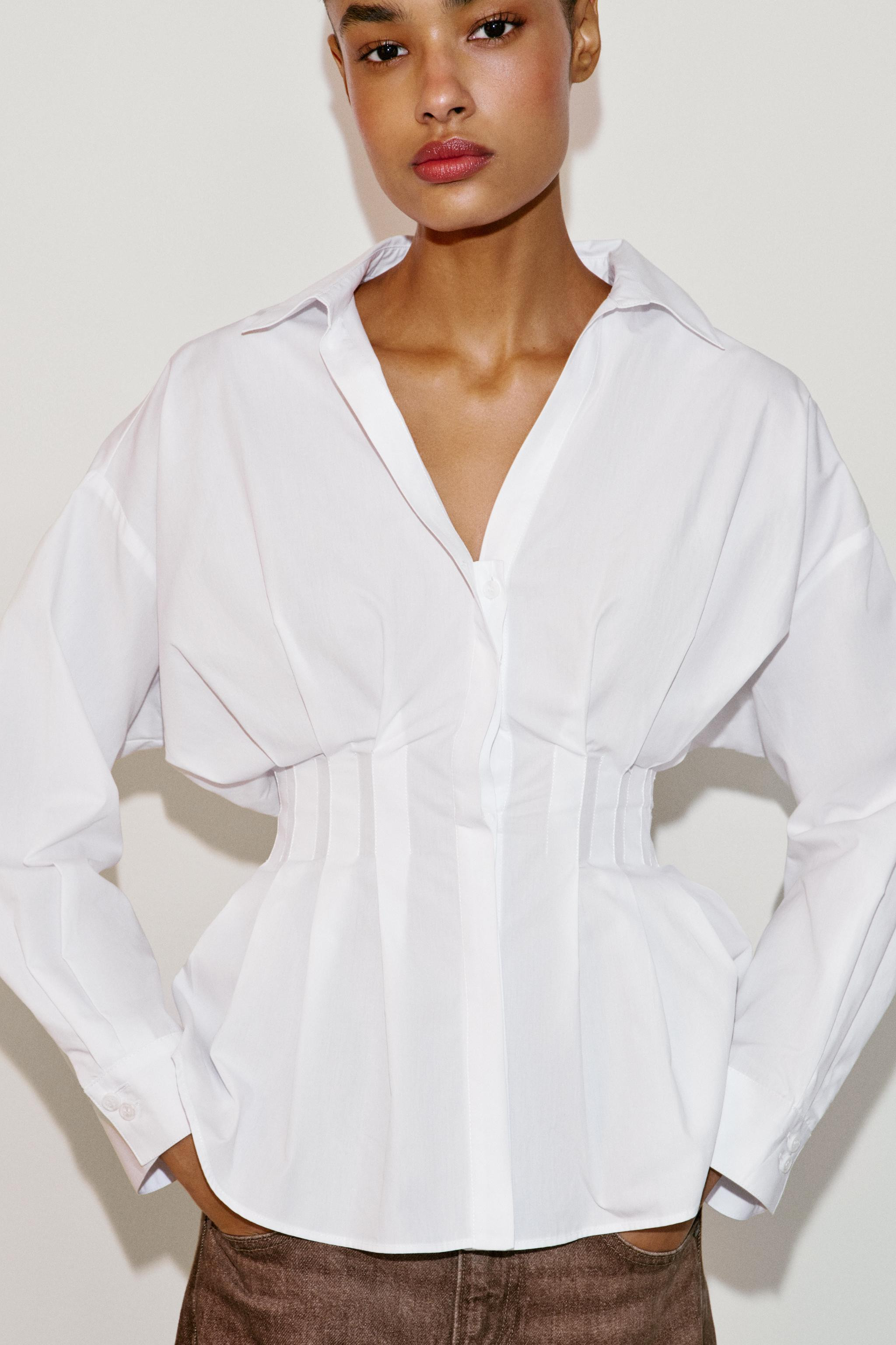 Shirt with a lapel collar, V-neckline, and long sleeves. Pleat detail at the waist. Front closure... | Zara US