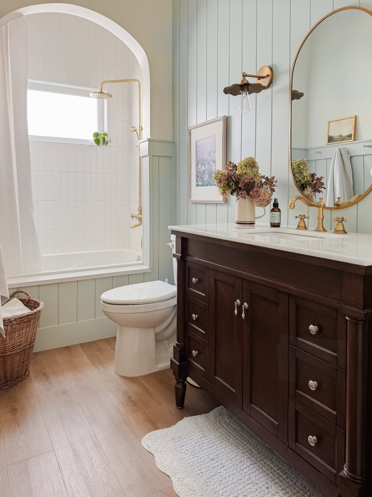 Shiplap bathrooms with arched tub, walnut vanity, gold pill mirror, floral wall sconces, brass shower fixture 

#LTKHome