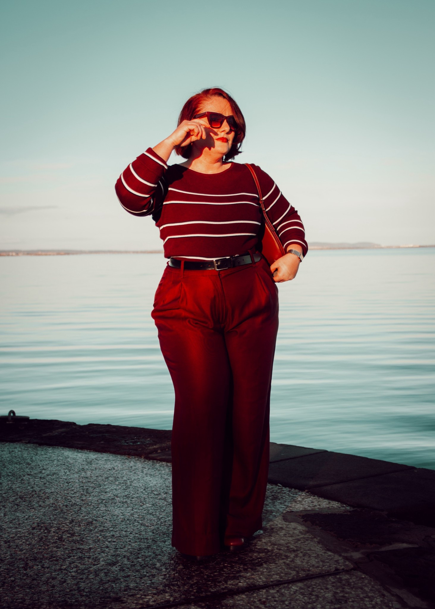 Rouge profond, coupe flatteuse et allure assumée ❤️
Aujourd’hui je mise sur un look monochrome ultra chic : pantalon taille haute fluide pour allonger la silhouette, maille rayée toute douce et accessoires ton sur ton pour la touche sophistiquée. Les lunettes apportent ce petit côté rétro que j’adore, parfait entre élégance et décontraction au bord de l’eau.

Une tenue simple, mais forte… le genre qui donne confiance dès qu’on l’enfile ✨