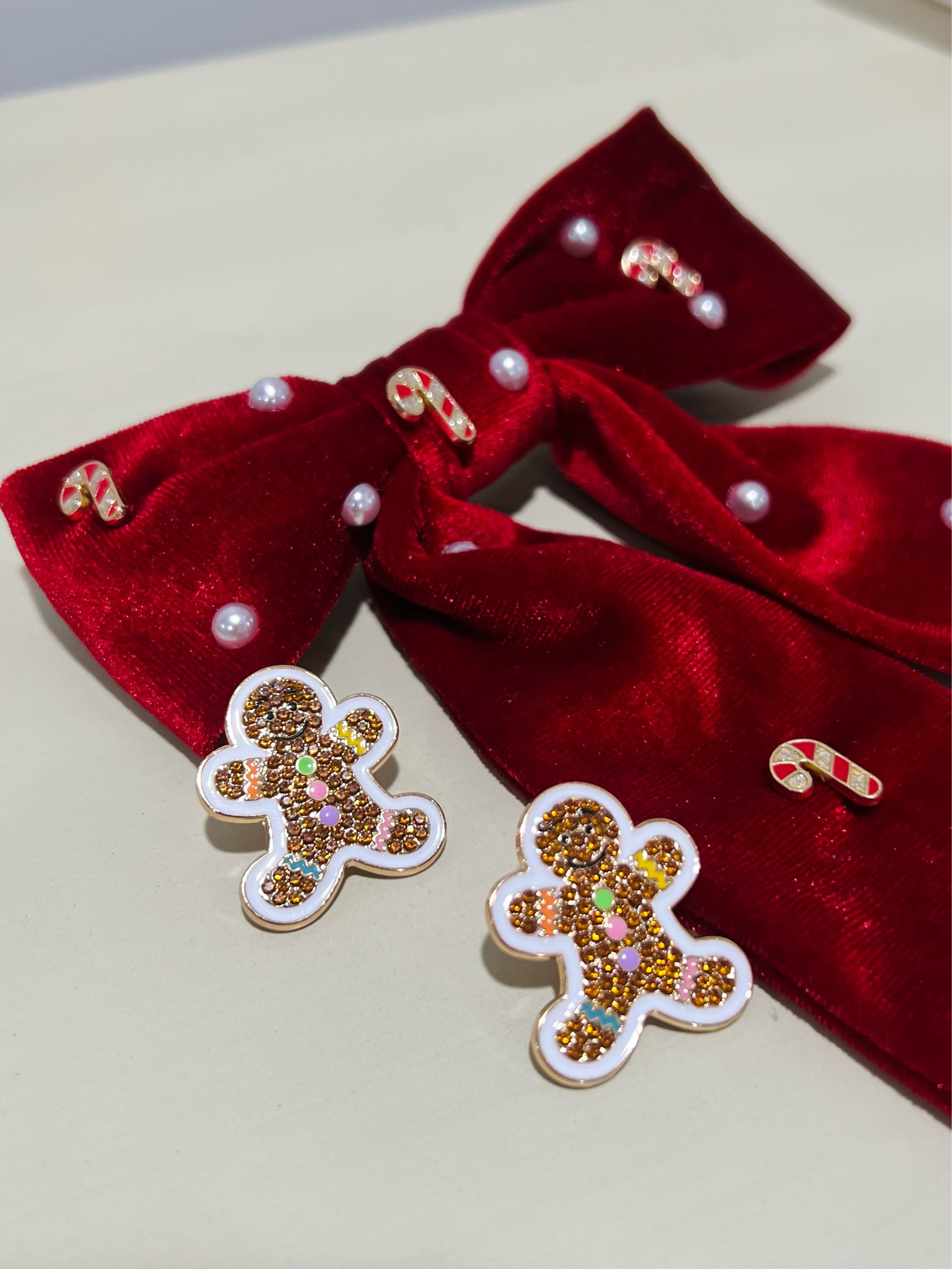 Holiday red hair bow with pearls and candy canes and gingerbread earrings. Bauble bar 

#LTKSeasonal #LTKstyletip #LTKHoliday