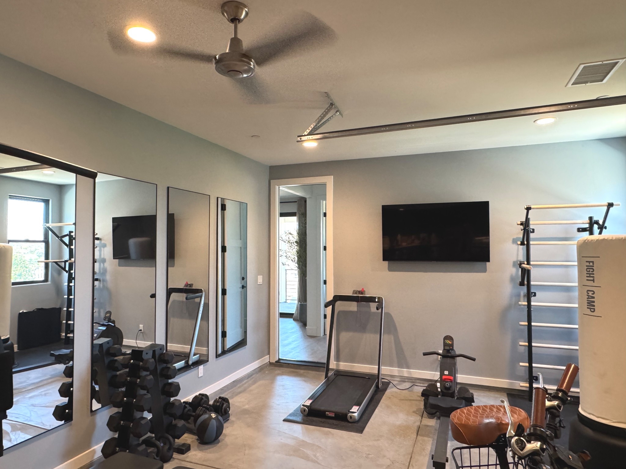 Indoor home gym setup | treadmill | weight set | rower | mirrored wall | Swedish wall bar | punching bag | free weights | medicine ball 

#LTKU #LTKHome #LTKMens