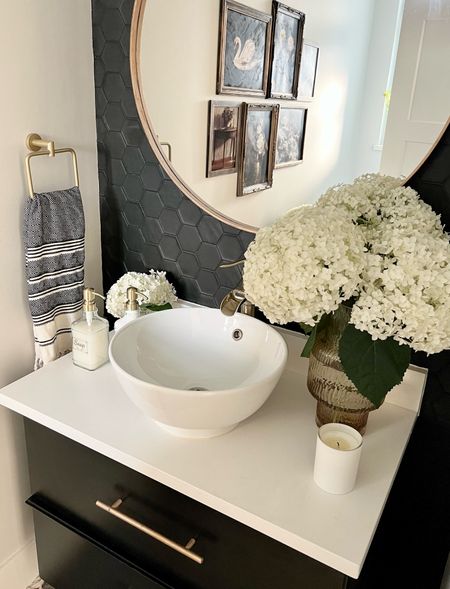 Powder room details: 
New glass bottles with gold pumps, and a few blooms of fresh hydrangeas to freshen up this moody bathroom! 
This tile was previously a grey and white mosaic. I painted it black with Fusion mineral paint. It worked so well! 
Home decor, bathroom styling

#LTKhome #LTKFind #LTKfamily