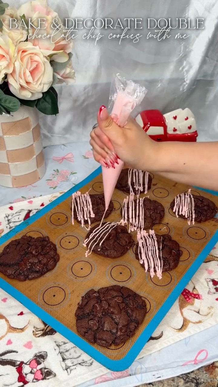 So I may have accidentally deleted the actual cookie dough making process so we did have to pivot. Its okay because the tutorial can be found in my December videos so just scroll back.
.
Recipe at the end for you to screenshot!
.
Ingredients:
*  2 cups of all-purpose flour
*  2⅓ cup of cocoa powder
*  ½ teaspoon of salt
*  2 teaspoons of baking powder
*  ⅓ cups of unsalted butter melted
*  1 cup of packed brown sugar
*  1 cup of granulated sugar
*  2 large eggs + 2 egg yolks at room temp
*  2 teaspoons of vanilla extract
*  2 cups of semisweet chocolate chips
Instructions:
1.  Preheat the oven to 350°F and line two baking sheets with parchment paper.
2.  In a large bowl, add the melted butter, brown sugar, and granulated sugar. Mix until well incorporated using an electric handheld mixer.
3.  Add the eggs, egg yolks, and vanilla extract to the bowl until well incorporated.
4.  Using a mesh sieve, sift in the flour, salt, baking powder, and cocoa powder. Mix well together until combined.
5.  Using a silicone spatula, fold in the chocolate chips by hand until evenly incorporated.
6.  Using a large cooking scoop, scoop the dough balls onto the parchment-lined baking sheet.�Roll each dough ball into a uniform sphere before spacing them 2 inches apart on the baking sheet.
7.  Bake for 9-12 minutes. Cool on the baking sheet.
8.  Serve & Enjoy!
.
#chocolatechipcookies #doublechocolatecookie #cookierecipe #baking #recipe