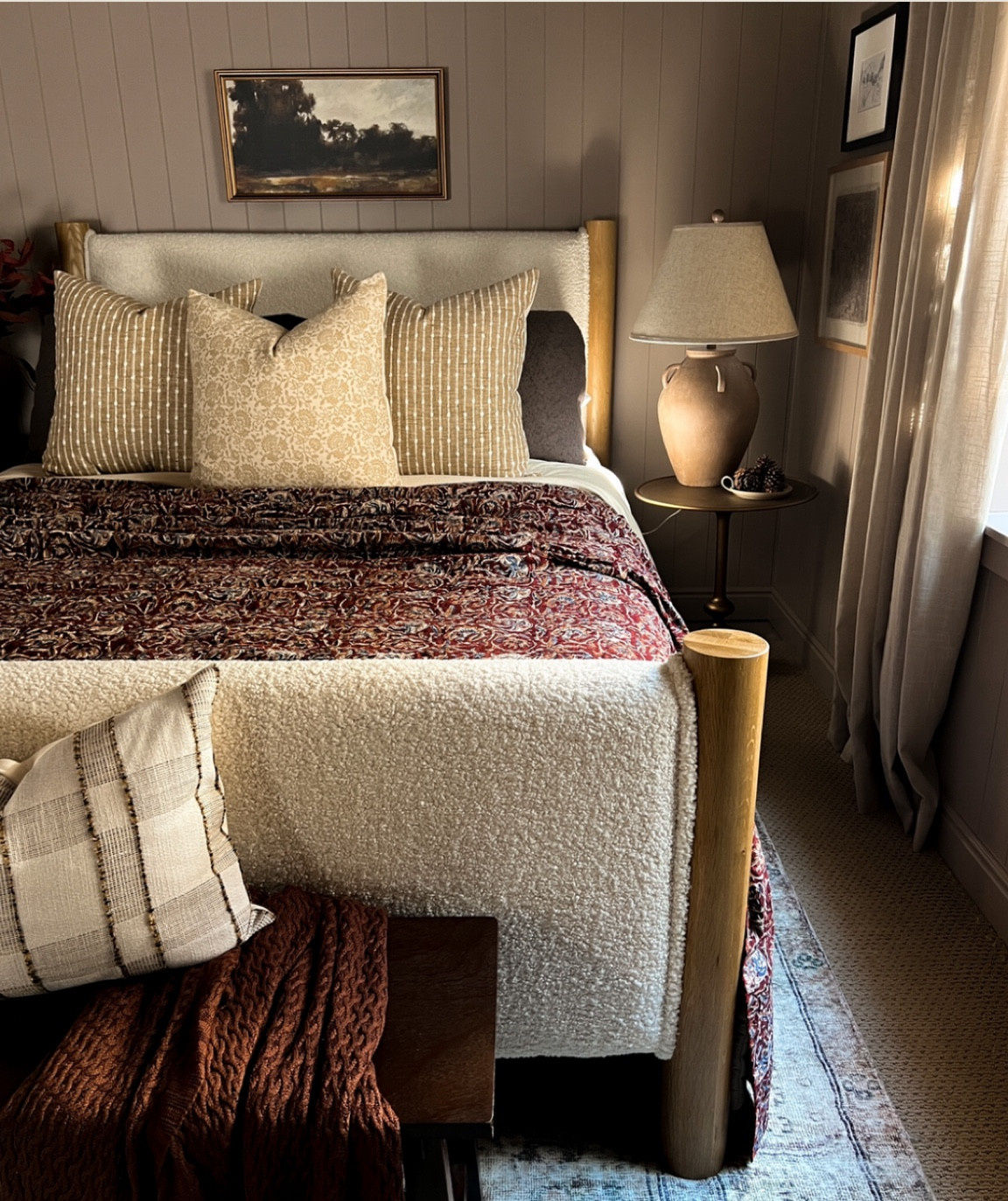 Moody guest bedroom 

Burgundy Kantha quilt, Loloi cloudpile rug in the color Sage/antique. Floral print and stripe print throw pillows, vintage urn look lamp, burgundy red stems 