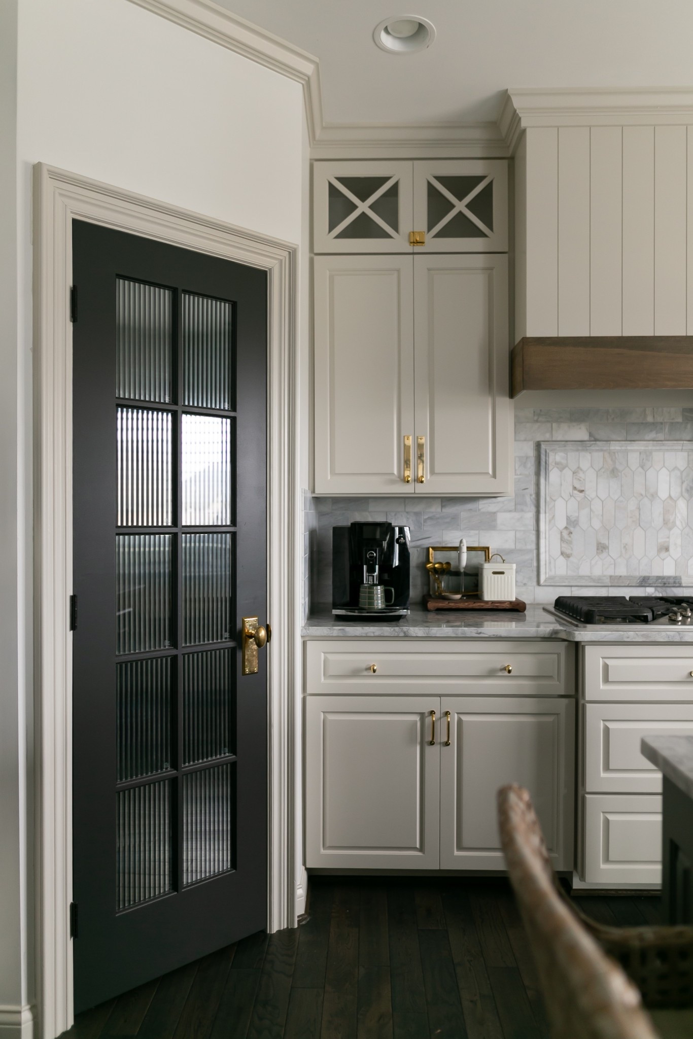 DIY faux fluted glass door.

Here are my tips:

Make a template of your glass, and cut your film to size BEFORE applying. This step was crucial as we tried to leave excess on all sides to trim with an xacto knife and the film kept coming loose and twisting leaving us with slanted fluting. 

Clean glass with alcohol and make sure there is no lint left on glass.

Spray glass and film with windex, and use a vinyl application kit to apply. 

Door is painted Sherwin Williams Iron Ore in eggshell. 