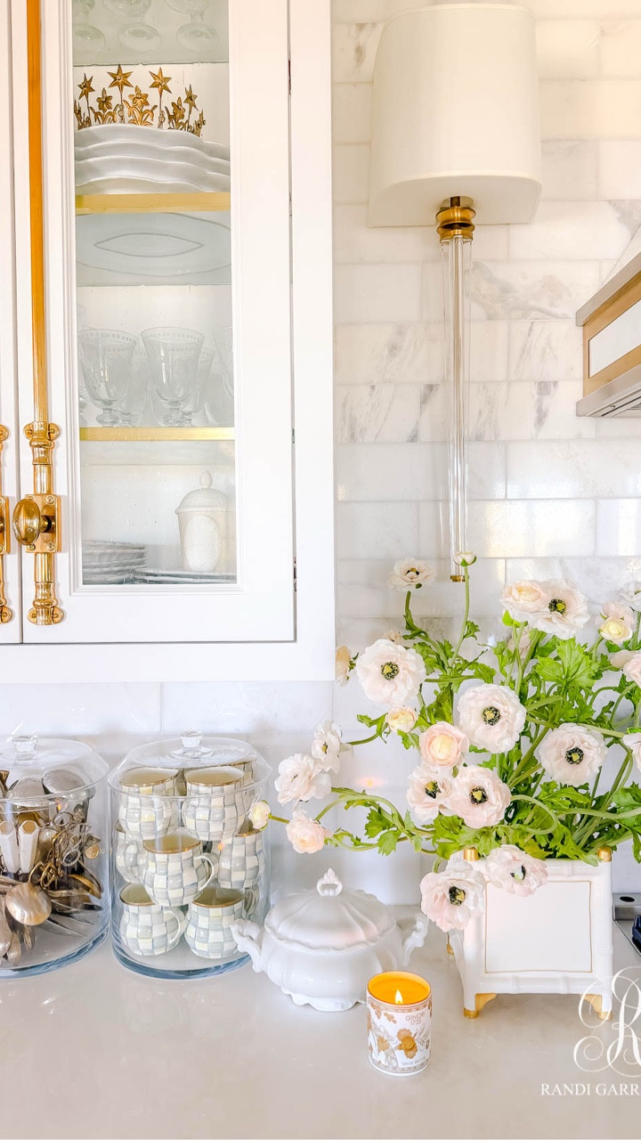 Flanking the stove, I styled these gorgeous, light pink ranunculus in white and gold cache pots. I used 8 ranunculus stems in each arrangement. They frame the range and add some charm and whimsy to the room.

Scent is such an important part of styling for me. These Ginori 1735 candles add a soft, refined aroma throughout the kitchen, while Coconut Papaya candles bring the most beautiful tropical sweetness that coordinates perfectly with the peachy pink florals.

#LTKHome #LTKSeasonal
