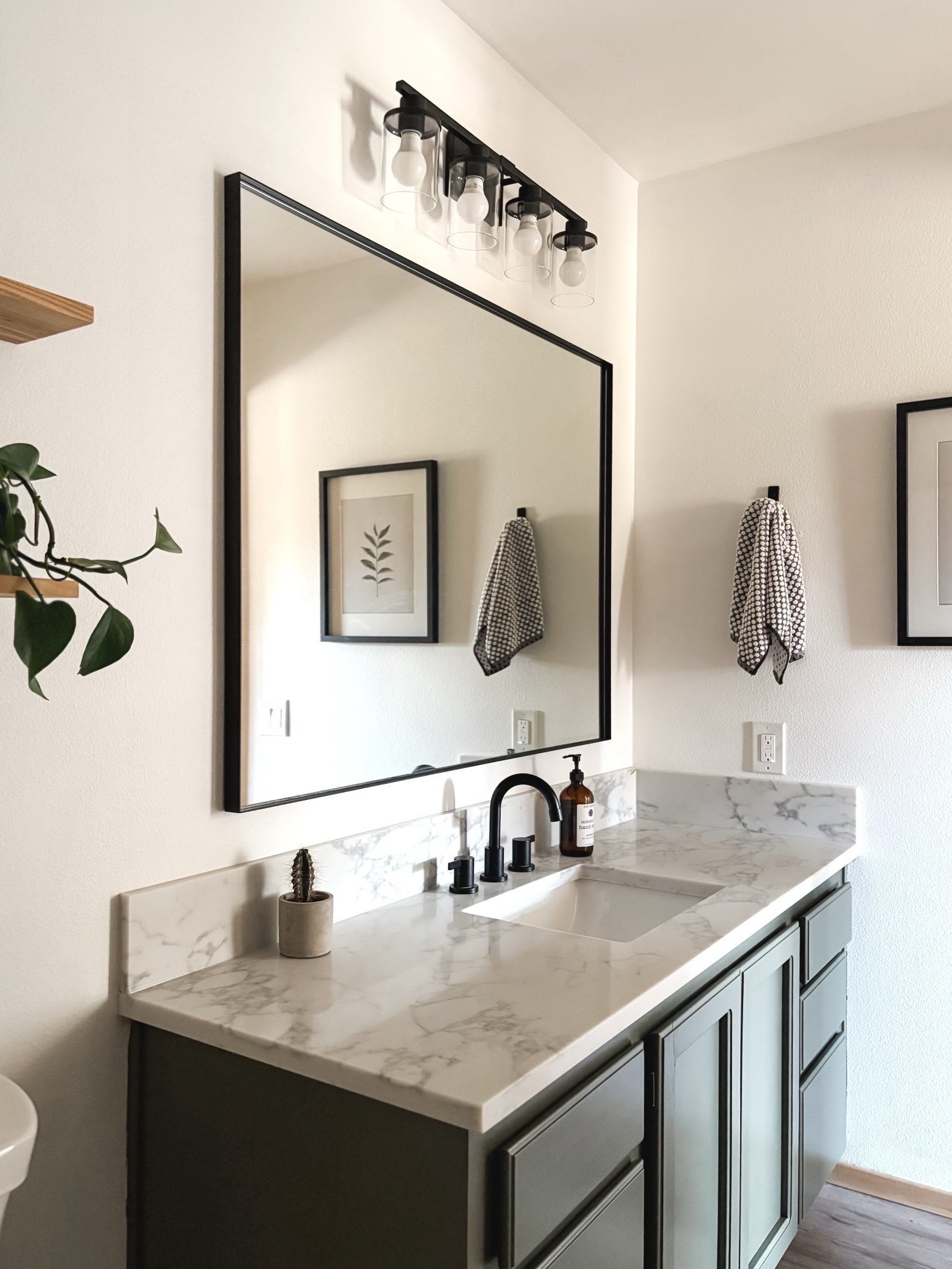 BATHROOM REMODEL: Organic modern bathroom update with fresh painted green cabinet, quartz countertops, metal framed mirror and vanity light plus a few details round out the update. 🖤🌿

#LTKHome