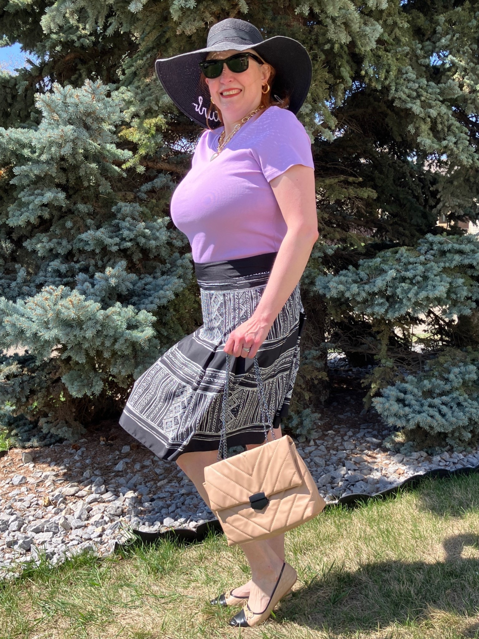Update: my husband got released from the hospital today! He’s home and doing well. Thanks so much for the prayers. I don’t have Bette Davis eyes, but I do feel like a silver screen star in this look! Take one large hat, and some mysterious shades and pair it with a lavender shirt, printed skirt, fab bag, and Chanel inspired flats, and you got a classy look indeed. I’d totally wear this to church or a brunch with the ladies. Canadians click on the first links to shop, and Americans click on the second links to shop. If there’s only one link then you can shop it in your own country. And remember, trendy doesn’t have to be expensive! Bye!

#LTKcanada #LTKsummer #LTKover50style