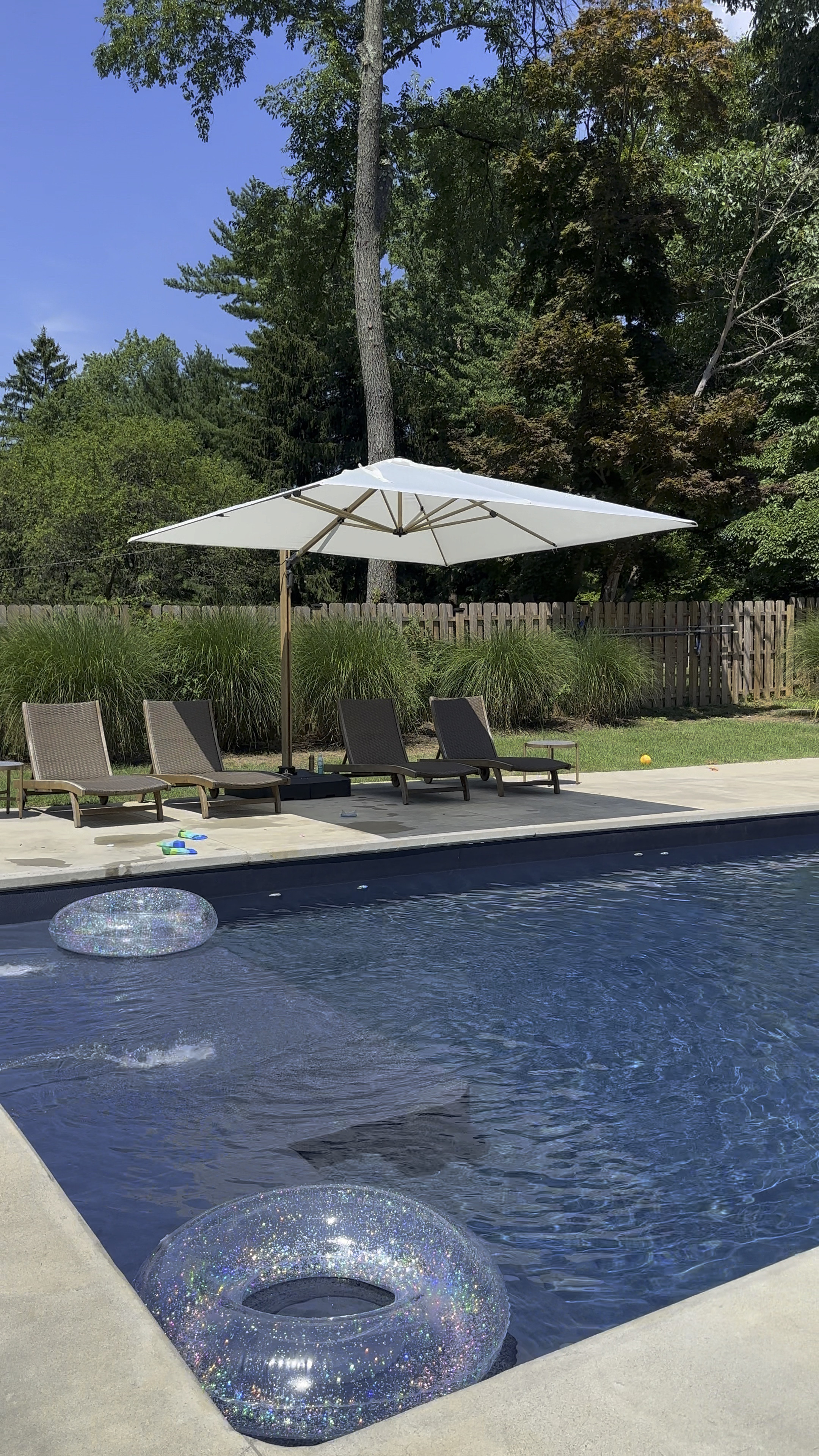 Pool day! My most trusted accessories. 
11x11 umbrella rotates 360 degrees and tilted several different levels to block the sun as it moves. This one is new but I’ve owned another for 3 years and it’s in perfect condition. Same with my loungers! Wheels and sliding tray tables. Adjustable backs. Comfy wicker. Teak. Best $5 tubes ever. Last years without needed to be re inflated! 

#LTKSeasonal #LTKHome #LTKSummerSales