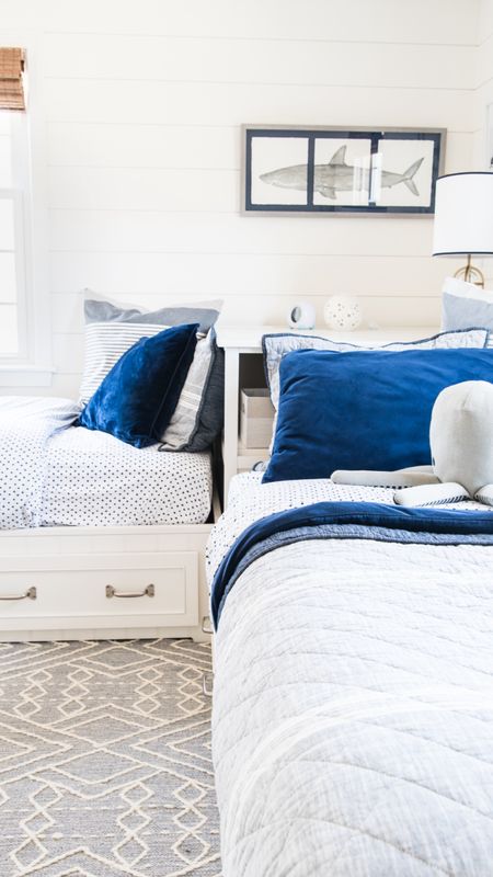 Coastal style shared boys bedroom with pottery barn storage beds, blue and white bedding and nautical themed accessories

#LTKhome #LTKkids