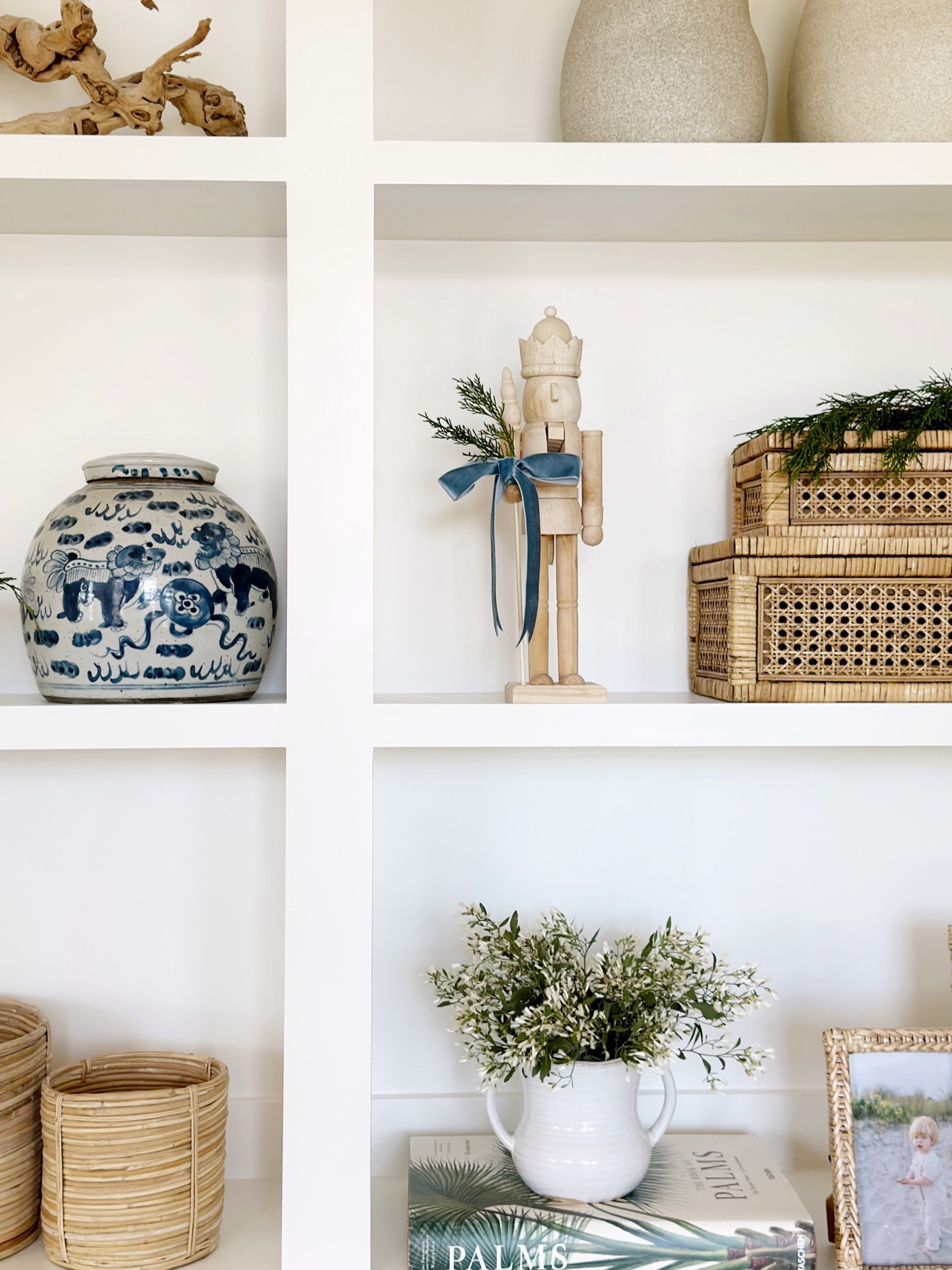 How I decorate my coastal cottage open shelving for Christmas! Loving the mix of different natural elements like ceramics, wood nutcracker, and rattan boxes. 

#LTKHome #LTKSeasonal #LTKxPrimeDay