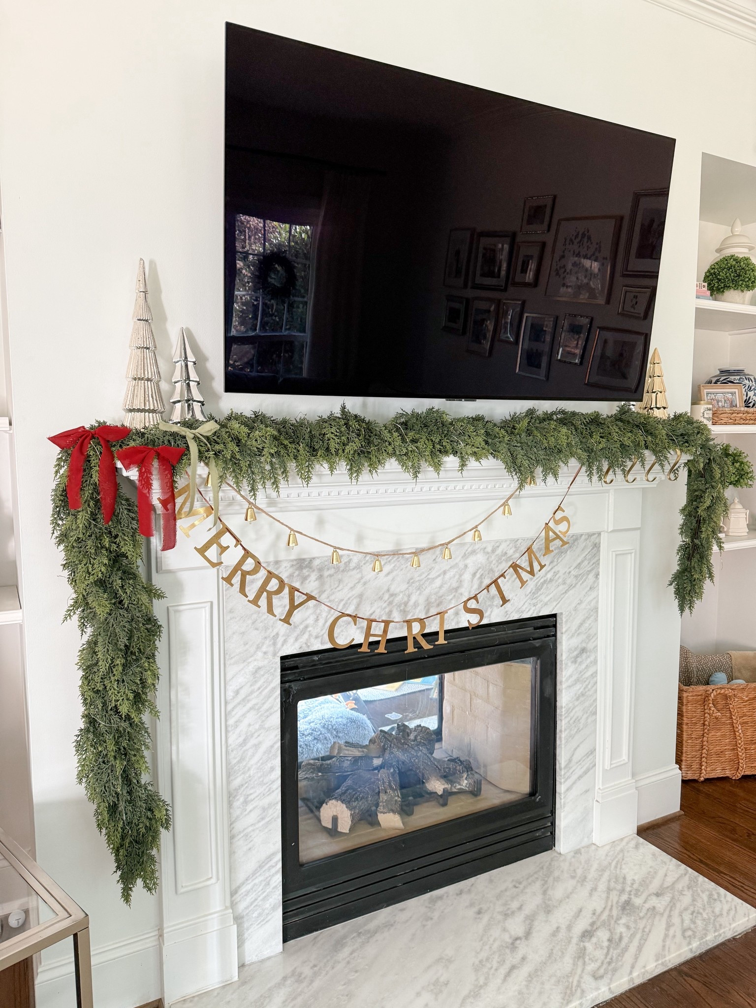Christmas fireplace mantle decor coming right up! 
I used one strand of each garland that is linked below. 
The bell garland, stocking holders and a few of the trees are from Hobby Lobby  

#LTKHoliday #LTKCyberWeek #LTKHome