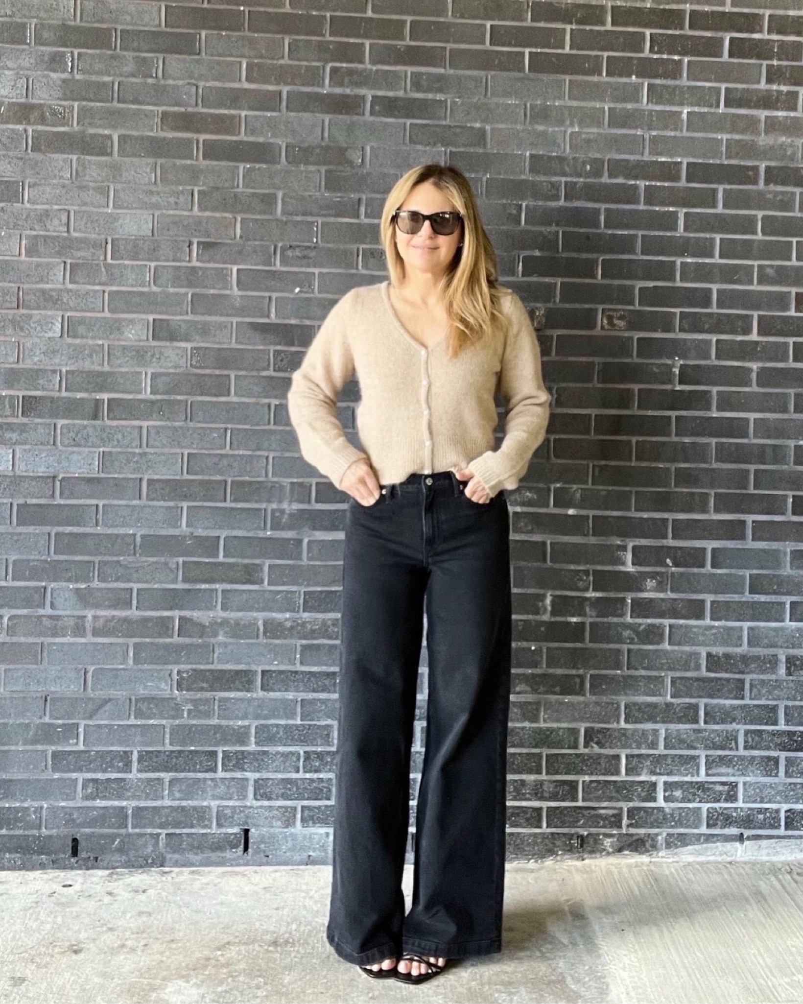 I’m wearing a work outfit here: it’s a beige wool v-neck cardigan that has pearl buttons down the front with high rise wide legged black jeans and strappy sandals.

#LTKCyberWeek #LTKstyletip #LTKworkwear