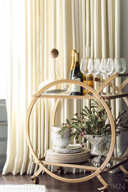My gold bar cart in my Iron Ire dining room is styled with a mix of neutral and natural entertaining items, like these gold rimmed wine goblets, driftwood chargers. Faux olive branches and wine decanter. home decor dining room decor bar cart styling holiday decor cereal bowls

#LTKhome #LTKstyletip #LTKunder50