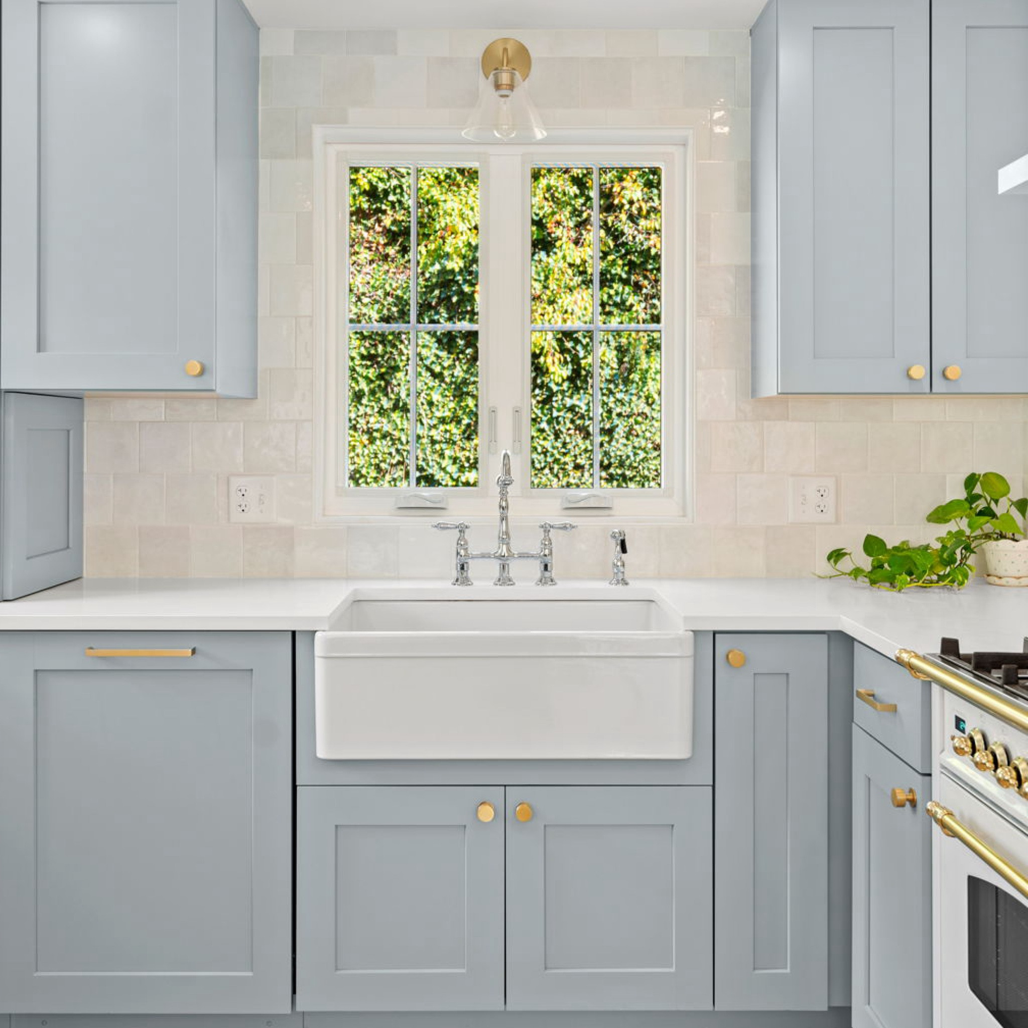 with this #dwelloctoberstudio design project, our goal was to transform a ‘90s builder grade kitchen into a bright and cheerful space that highlighted the home’s gorgeous natural light and serene feeling. we opted for warm brushed brass cabinet hardware to balance out the cool blue tones of the cabinetry. a white range with brass knobs serves as a focal point on one wall and adds a bit of elegance to the space. white glazed tile, a bell-shaped wicker pendant light, and rattan counter stools provide soft, natural textures. #dwelloctober

#LTKhome