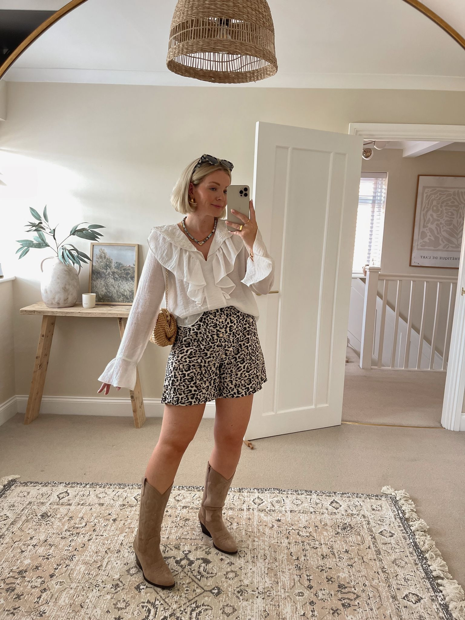 Chic summer festival & Ibiza outfit ideas - white ruffle trim blouse, asos leopard print shorts, beige suede cowboy boots, mango raffia clutch, & other stories tortoiseshell cat eye sunglasses, Carrie Elizabeth blue beaded necklace  

#LTKsummer #LTKstyletip #LTKuk