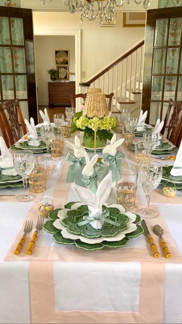 Spring has sprung, and so have my Easter table preparations! 🌸🐰 I've been hopping into action, blending cherished traditions with a sprinkle of whimsy for this year's setup. Did you catch the bunny napkin fold I shared yesterday? It's just one of the playful touches I've added. This season, it's all about welcoming the beauty around us and creating memorable moments. My table boasts a mix of blush pink and white linens, complemented by green and white Geranium tableware and bamboo flatware for that timeless look. Crystal and rattan glassware elevate the elegance, while gold leaf and rattan table lamps with adorable scallops add a chic twist. Each guest's spot is marked by a bunny-folded napkin tied with a green bow. On either side of the table are the cutest white bunnies sporting green ribbon neckties, not to mention my whimsical blooming cabbage centerpiece. And the buffet? A true bunny haven! 🌿🍽️💕 Are you dressing up your table for Easter? I'm egg-cited to see how you're embracing this beautiful season! Share your plans below and let's make this Easter unforgettable together.🐰🌷🥬
.
.
.
#eastertable #housebeautifulhome #traditionalhomemagazine #solinohome #dressingthetable #victoriamag #tablescapestyle #classichomedecor #mytradhome #springtable #springtablescape #southernladymag #thecottagejournalmagazine #mycollectedhome #entertainathome #playwithyourdishes #myupcountrystyle #postitandsmile #thecollectedlook #bordallopinheiro #betterhomeandgardens #easterinspiration #festivedecor #diningroominspiration #entertainingideas #preppygrandhome #traditionalinterior #entertainandcelebrate

#LTKSeasonal #LTKparties #LTKhome
