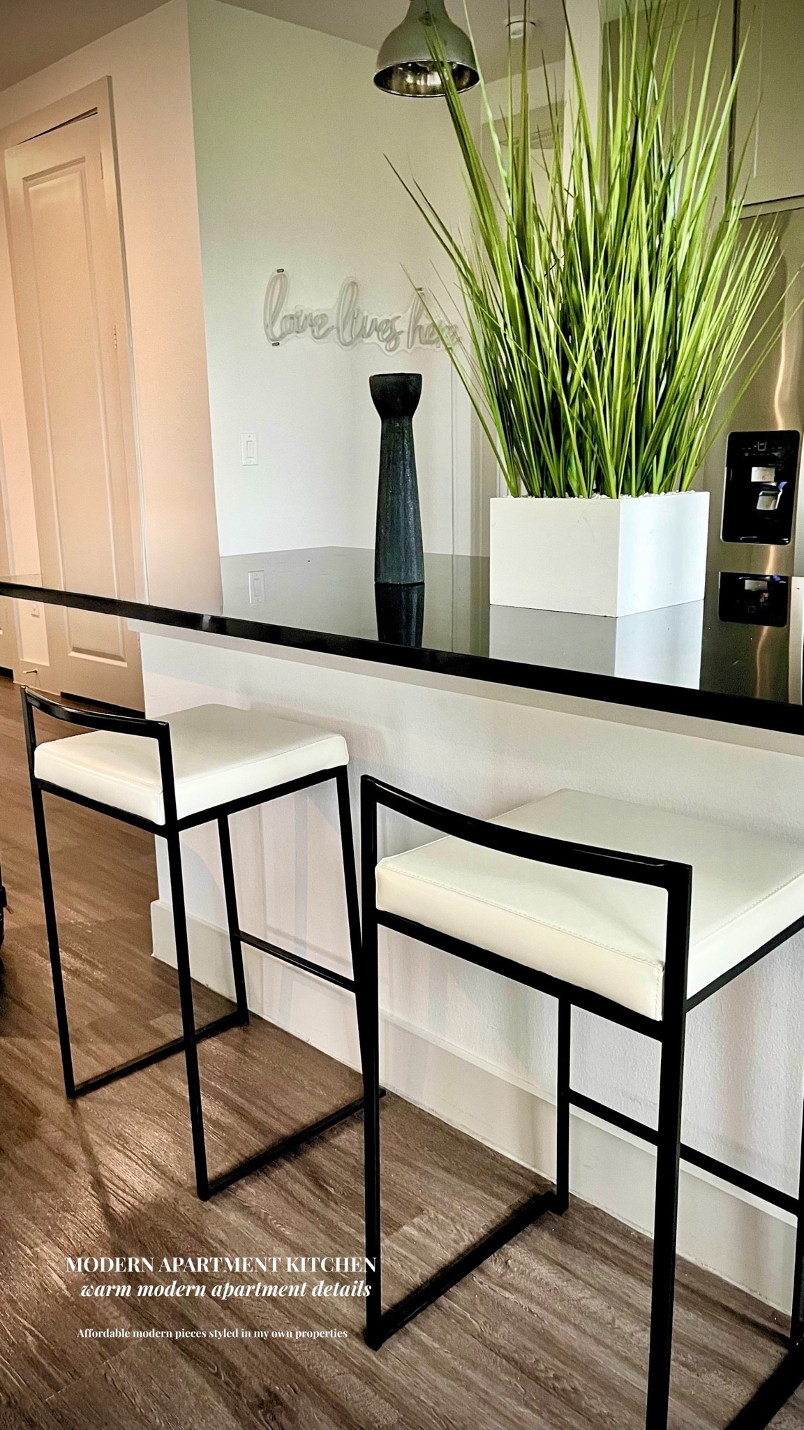 Modern Apartment Kitchen Decor | Black & White Barstools + Warm Modern Styling

Warm modern apartment details with a monochrome edge 🤍🖤 These affordable barstools completely changed the look of this kitchen and made the space feel elevated without overdesigning it. I love mixing clean black lines, soft white textures, warm wood flooring, and simple modern decor for a look that feels designer but still livable. Linked the barstools, decor, and similar apartment-friendly pieces from this space in my LTK.

#LTKHome #ModernApartment #ApartmentDecor #KitchenStyling #ModernKitchen #BarstoolStyle #MonochromeHome #WarmModern #ApartmentInspo #MinimalHome #BlackAndWhiteDecor #KitchenInspo #NeutralHome #AffordableHomeDecor #ContemporaryHome #InteriorStyling #HomeDetails #KitchenDecor #LTKStyle #DesignerInspired