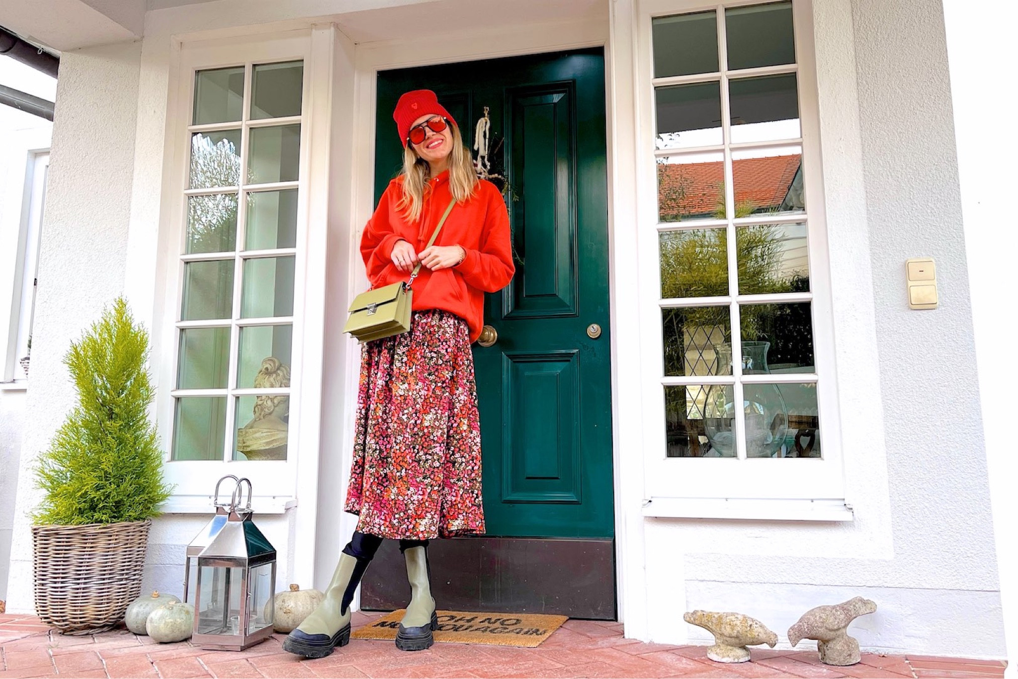 Cute Casual. Fashion and Style Blog Girl from Heartfelt Hunt. Girl with blonde hair wearing an orange beanie, orange sunglasses, orange hoodie, floral dress, green statement bag and green chunky boots. #colorfuloutfit #colorfulstyle #colorfulfashion #colorfullooks #fashionfun #cutefalloutfit #fallfashion2022 #falllookbook #fitcheck #dailylooks #dailylookbook #contentcreator #microinfluencer #discoverunder20k