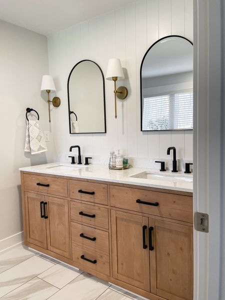 This client bathroom vanity is sturdy, wood and so beautiful for a modern farmhouse vibe.   It is only $1850!  

Wayfair Double vanity.   Master bathroom.  Bathroom floor tile.  Arched black mirror.  Brass sconce.  Black bridge faucet.  

#LTKhome #LTKsalealert #LTKfamily