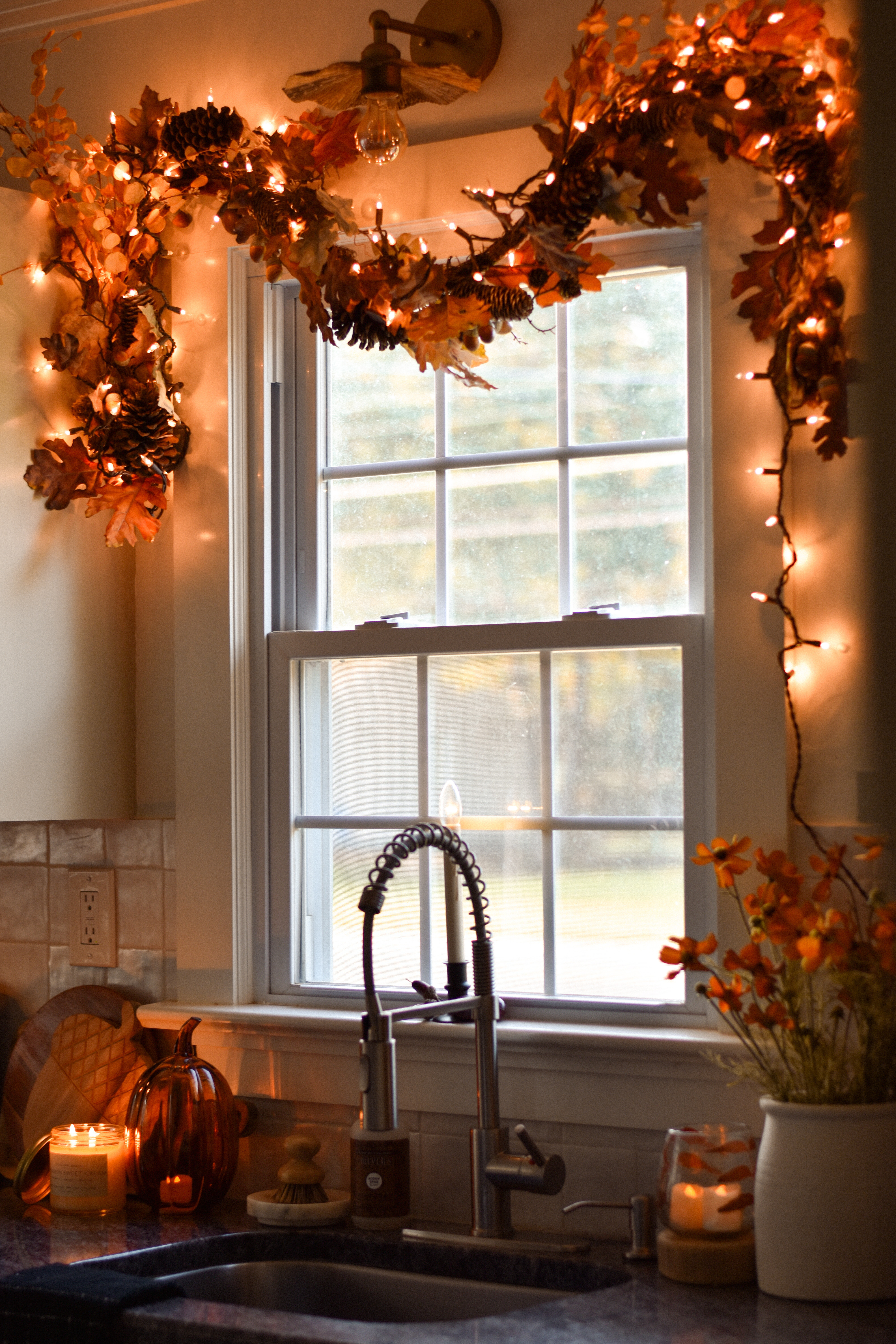 (7/31/25) Cozy fall kitchen vibes are here! 🍂 

I added this simple fall garland with twinkle lights around our window and it instantly made the space feel warm, festive, and like autumn!

Fall garland, flowers, and pumpkin are from hobby lobby, but linked similar items!

Candle is from Little White Shed & Co. (www.littlewhiteshed.com) 

 #LTKSeasonal #LTKHome #LTKFindsUnder50