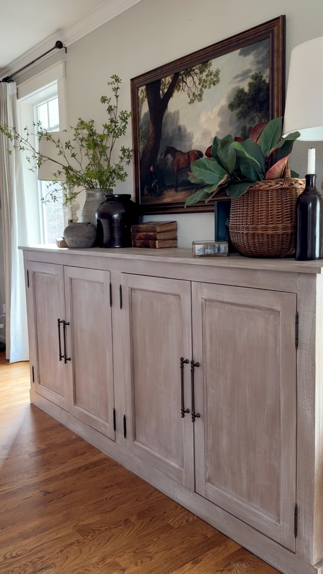 European antique charm i Our sideboard makeover brings collected, curated style to life.
We layered vintage and Amazon pottery that feels timeless, icy and snowy winter stems, and old books to add story and depth. Vintage brass candleholders and antique-style duck head bookends (Amazon find!) give character, while a European basket with realistic magnolia stems adds softness and life.
The look is grounded with a beautiful equestrian art print from a small shop, and mercury lamps on each end provide perfect balance and symmetry. Every layer brings texture, history, and effortless European farmhouse elegance

#LTKSeasonal #LTKvlog #LTKHome