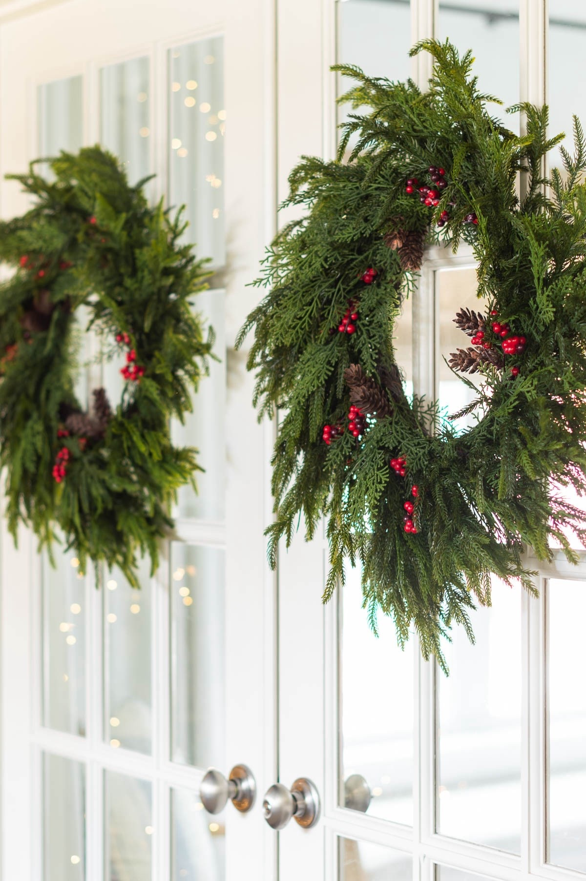 I love to sprinkle wreaths around my home during the holidays and I added these gorgeous green wreaths with pinecones and red berries to the French doors in my conversation room. Any door or mirror is fair game! 

#LTKHome #LTKFindsUnder50 #LTKHoliday