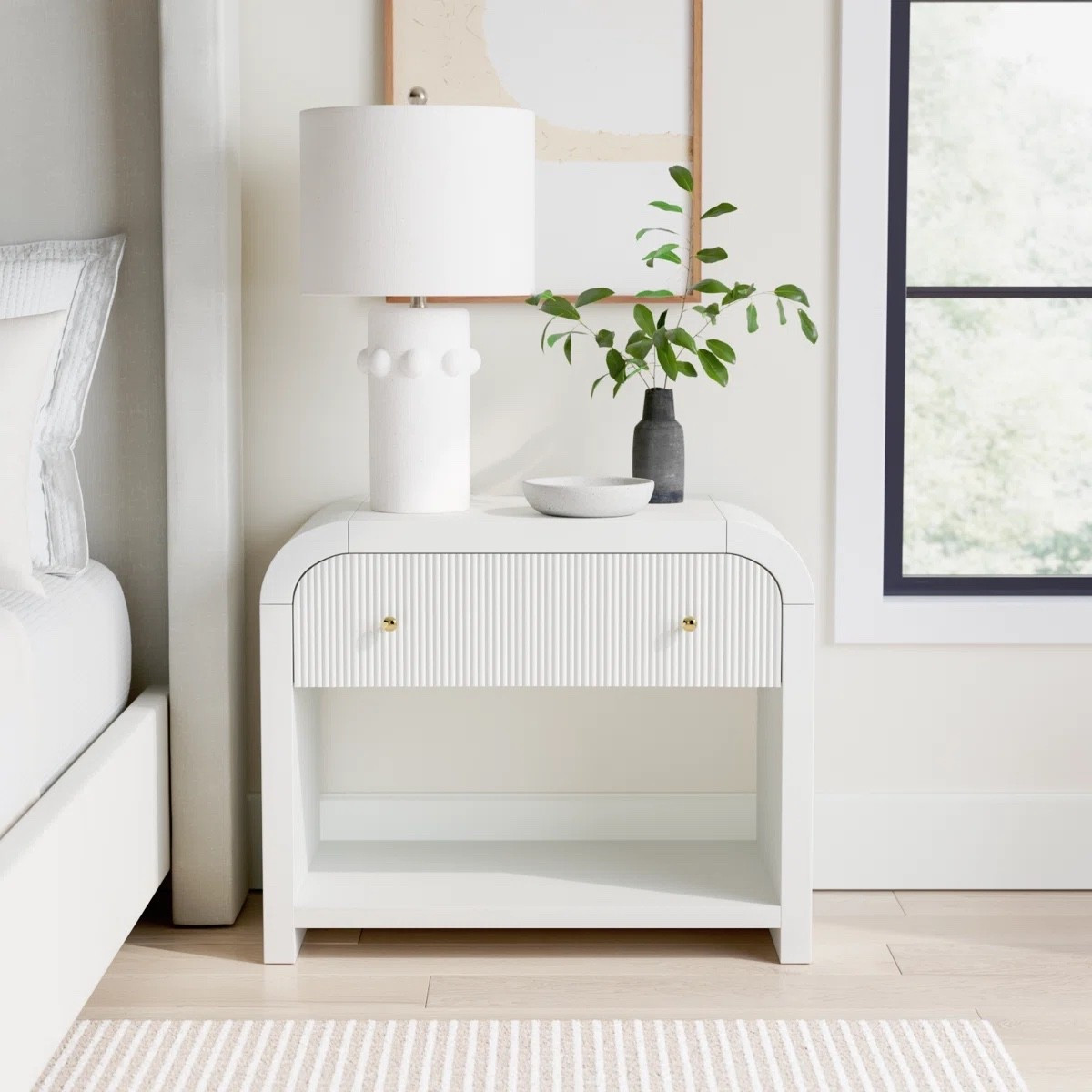 This white fluted nightstand from Wayfair is such a beautiful statement piece for a modern bedroom. The curved edges, textured drawer front, and brass knob add subtle detail while keeping the look clean and elevated. Style it with a sculptural table lamp, small vase, and framed art for a soft, designer inspired bedside setup.

#LTKHome