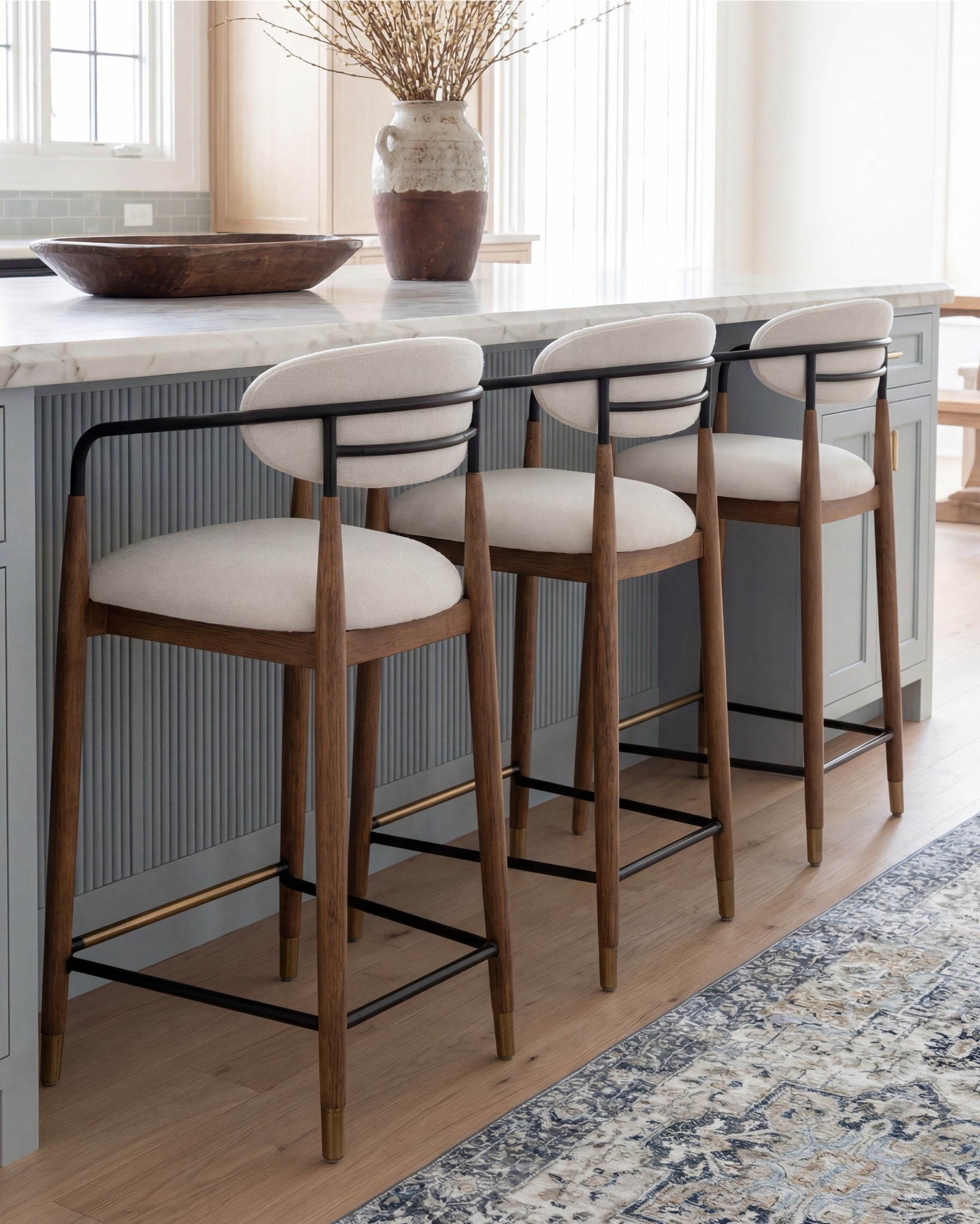This kitchen is the definition of soft luxury done right. The pale blue island brings a calm, collected energy, while the warm oak cabinetry and exposed beams add that natural depth you can’t fake.

The oversized globe pendants keep everything feeling airy and modern, and the marble countertop? Effortless elegance. Even the runner pulls the whole palette together with those muted blues and warm neutrals.

It’s the kind of space that feels lived-in yet elevated—where morning coffee somehow tastes better and slow dinners feel intentional.

Shop the Look:
• Light blue fluted kitchen island
• Warm oak kitchen cabinets
• Brass globe pendant lights
• Marble kitchen countertop
• Neutral blue patterned runner
• Black + brass bar stools
• Soft blue subway tile backsplash
• Brown Ceramic vase with branches
• Gold kitchen faucet and hardware
• Brown bowl 
• Brown floral wall art
• Black candle holder

#LTKsale #LTKhome #LTKstyletip